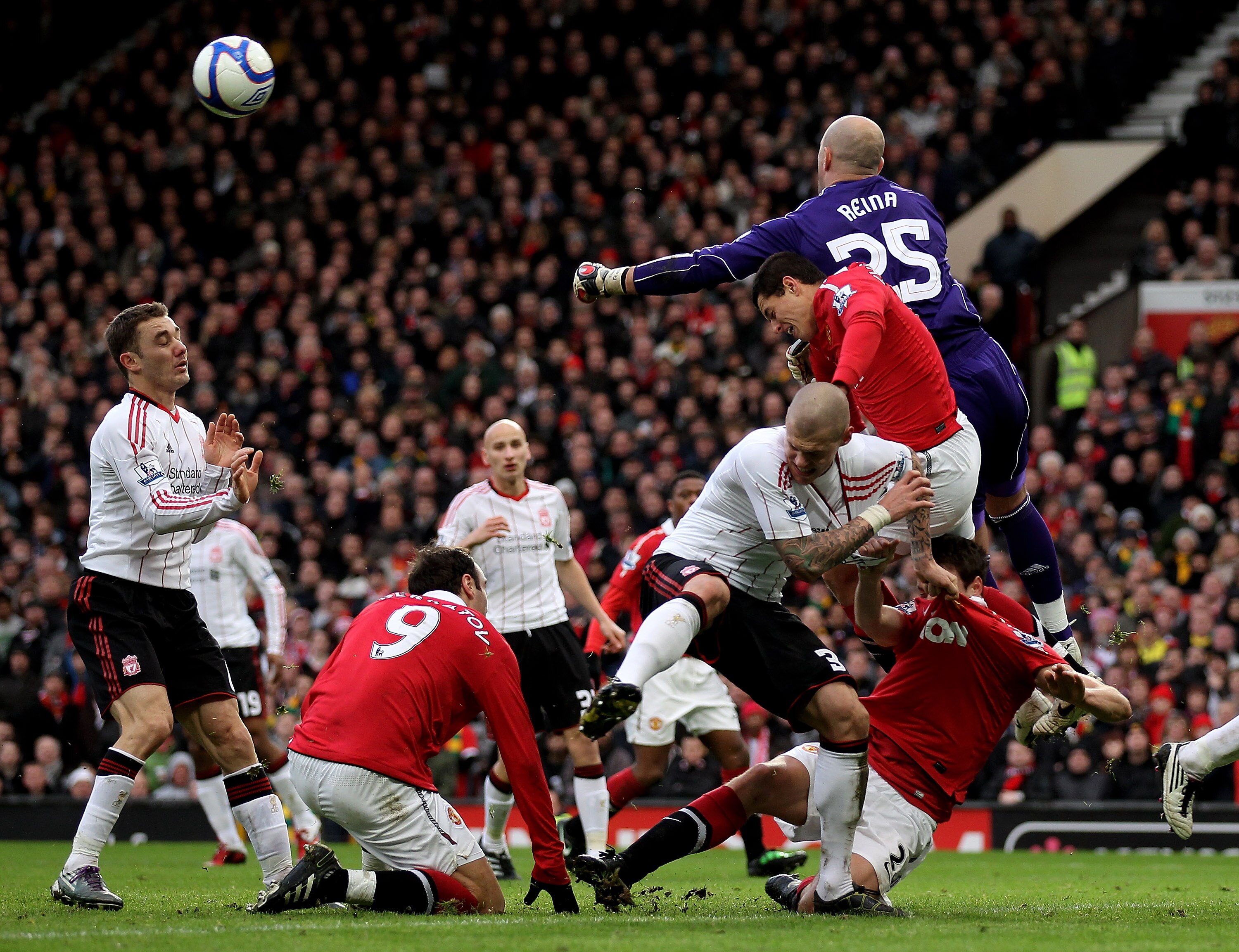 MANCHESTER, ENGLAND - JANUARY 09:  Pepe Reina of Liverpool punches clear as players from both sides compete for the ball during the FA Cup sponsored by E.ON 3rd round match between Manchester United and Liverpool at Old Trafford on January 9, 2011 in Manc