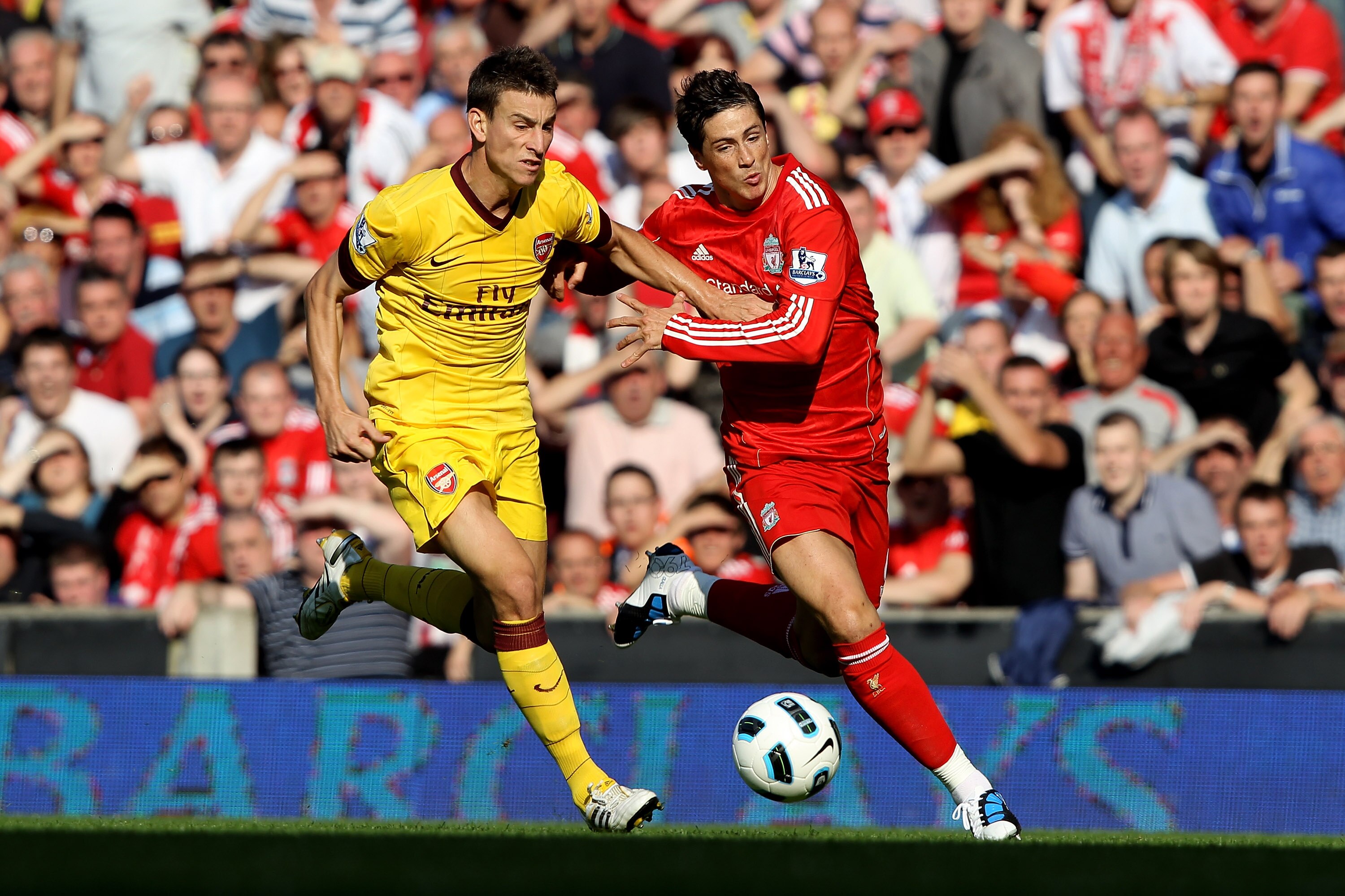 LIVERPOOL, ENGLAND - AUGUST 15:  Fernando Torres of Liverpool tussles for posession with Laurent Koscielny of Arsenal during the Barclays Premier League match between Liverpool and Arsenal at Anfield on August 15, 2010 in Liverpool, England.  (Photo by Cl