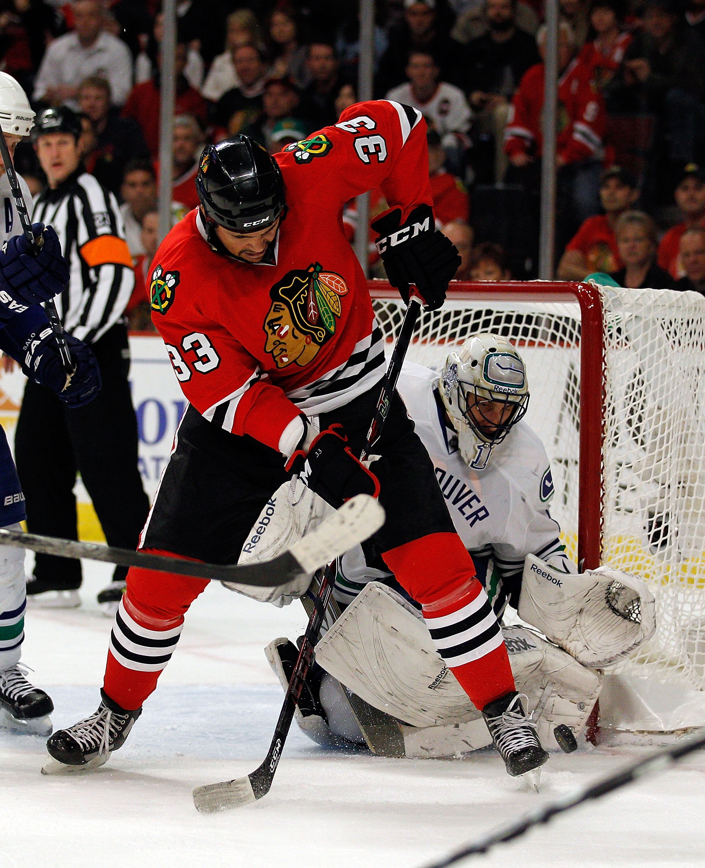 CHICAGO - MAY 09: Dustin Byfuglien #33 of the Chicago Blackhawks tries to slip the puck past Roberto Luongo #1 of the Vancouver Canucks in Game Five of the Western Conference Semifinals during the 2010 NHL Stanley Cup Playoffs at United Center on May 9, 2