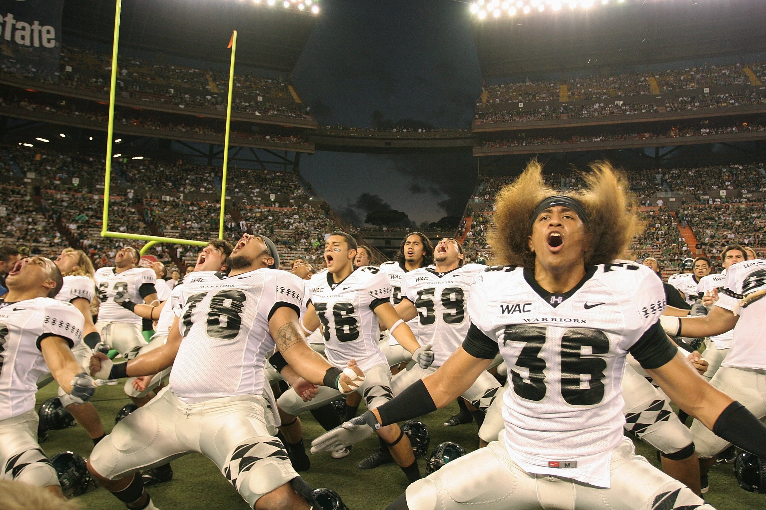 HONOLULU - DECEMBER 2:  Viliami Nauahi #36 (right), Greg Salas #36 (center), Keoni Steinhoff #78 (left) and other players of the Hawaii Warriors perform the Warrior dance, the Haka, before the game against the Washington Huskies on December 1, 2007 at Alo