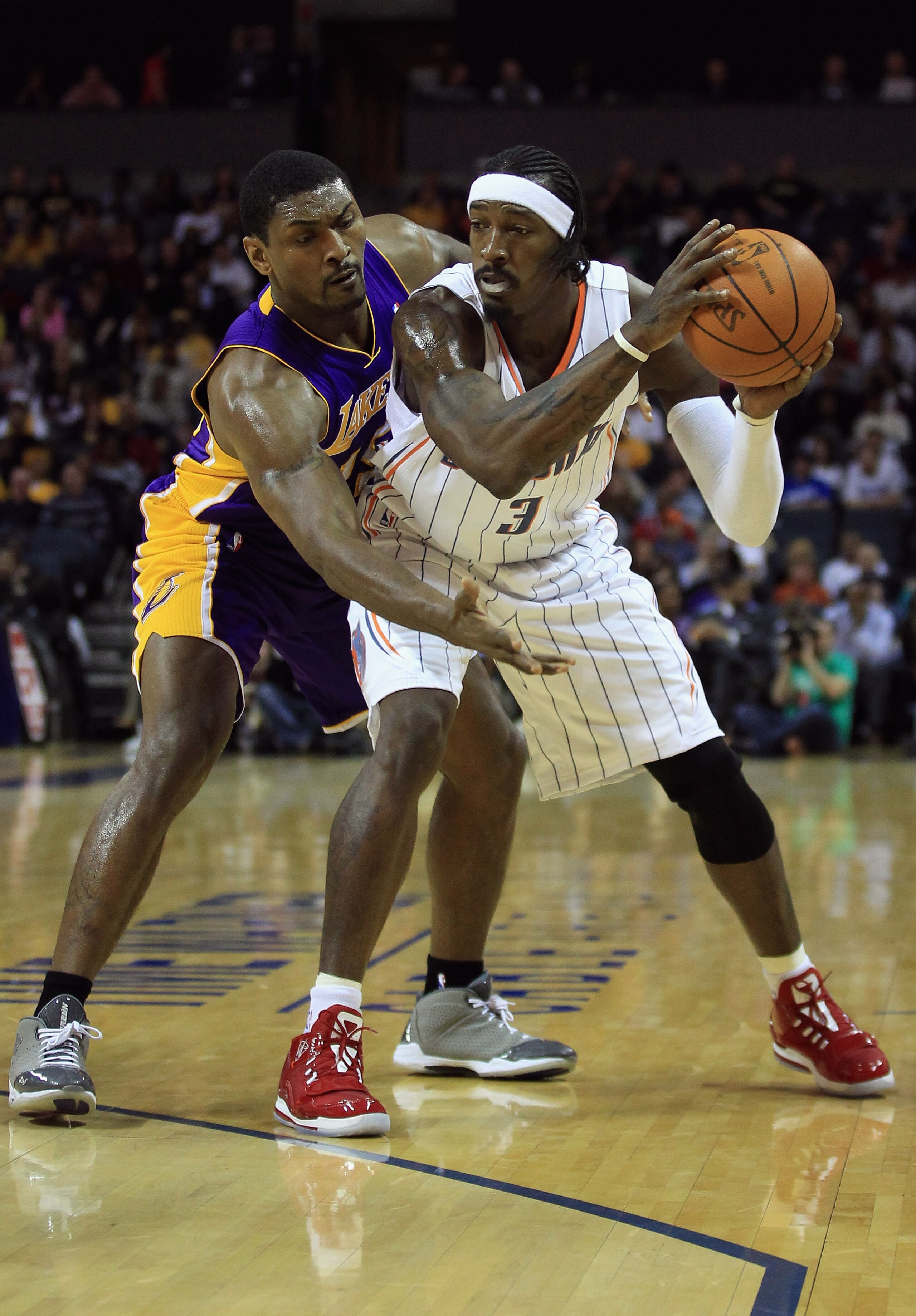 CHARLOTTE, NC - FEBRUARY 14: Ron Artest #15 of the Los Angeles Lakers reaches for the ball against Gerald Wallace #3 of the Charlotte Bobcats during their game at Time Warner Cable Arena on February 14, 2011 in Charlotte, North Carolina. NOTE TO USER: Us CHARLOTTE, NC - FEBRUARY 14: Ron Artest #15 of the Los Angeles Lakers reaches for the ball against Gerald Wallace #3 of the Charlotte Bobcats during their game at Time Warner Cable Arena on February 14, 2011 in Charlotte, North Carolina. NOTE TO USER: Us