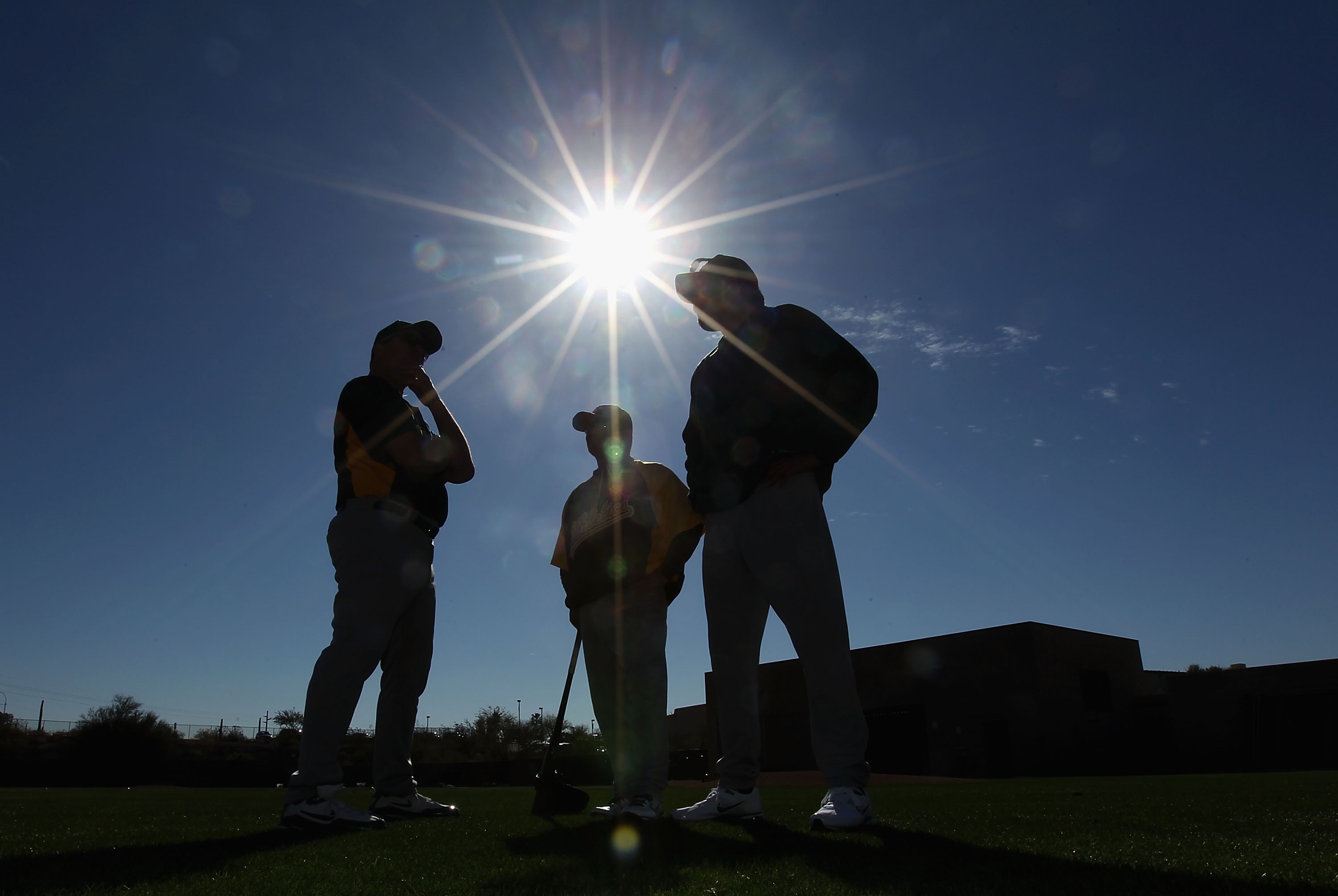 PHOENIX, AZ - FEBRUARY 16:  Manager Bob Geren, coach Mike Gallego and bench coach Rick Rodriguez of the Oakland Athletics talk during a MLB spring training practice at Phoenix Municipal Stadium on February 16, 2011 in Phoenix, Arizona.  (Photo by Christia