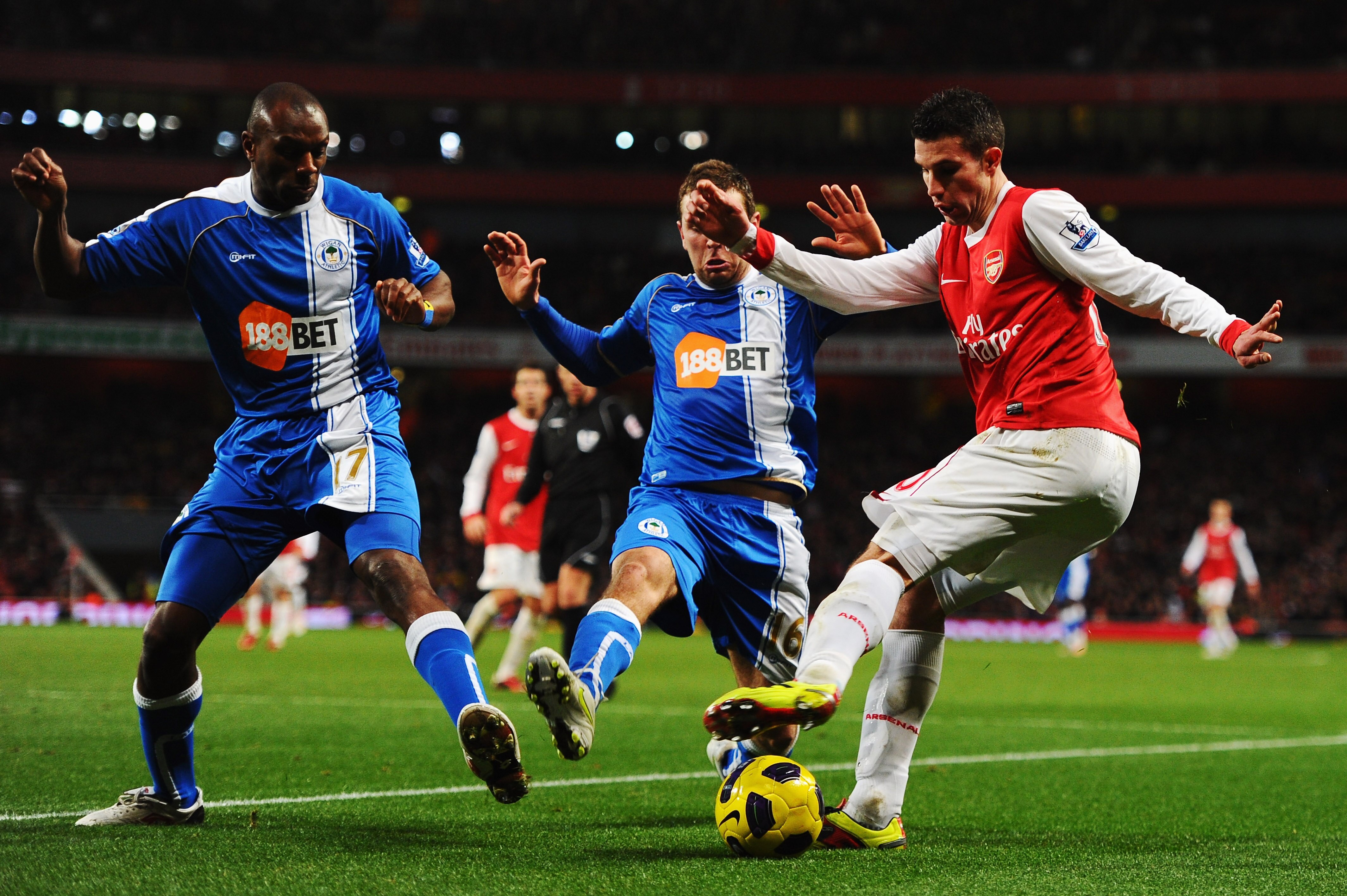 LONDON, UNITED KINGDOM - JANUARY 22:  Robin Van Persie (R) of Arsenal eludes James McArthur (C) and Emmerson Boyce (L) of Wigan Athletic during the Barclays Premier League match between Arsenal and Wigan Athletic at the Emirates Stadium on January 22, 201