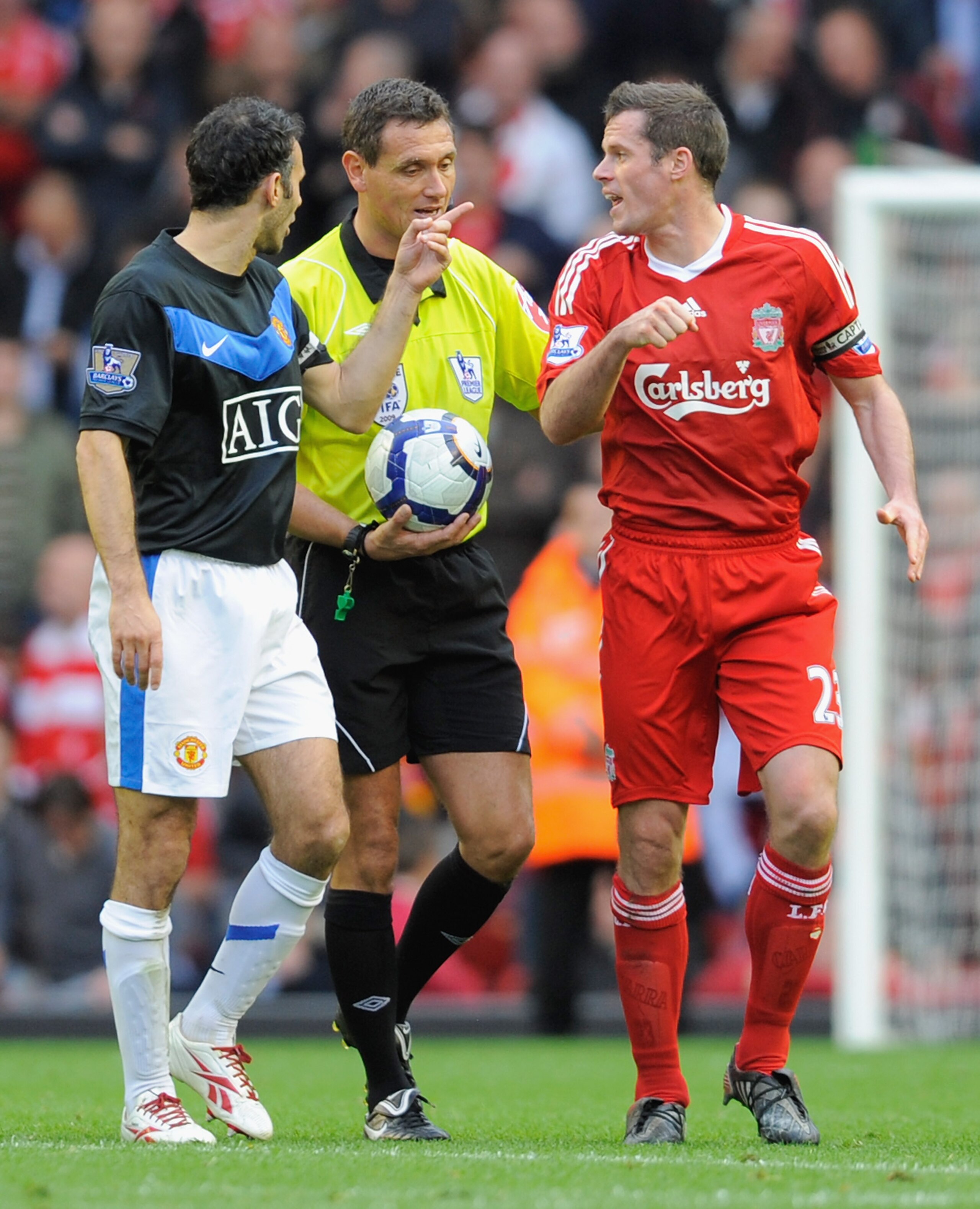 LIVERPOOL, ENGLAND - OCTOBER 25:  Jamie Carragher (R) of Liverpool and Ryan Giggs of Manchester United have words with Referee Andre Marriner during the Barclays Premier League match between Liverpool and Manchester United at Anfield on October 25, 2009 i