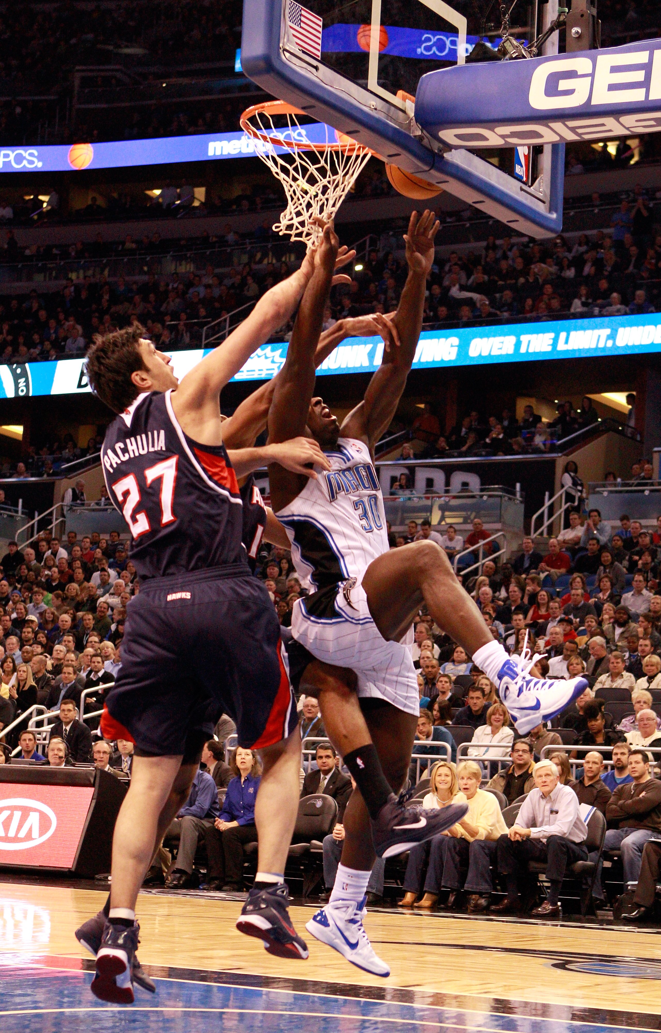 ORLANDO, FL - DECEMBER 06:  Brandon Bass #30 of the Orlando Magic attempts a shot over Zaza Pachulia #27 of the Atlanta Hawks during the game   at Amway Arena on December 6, 2010 in Orlando, Florida. NOTE TO USER: User expressly acknowledges and agrees th