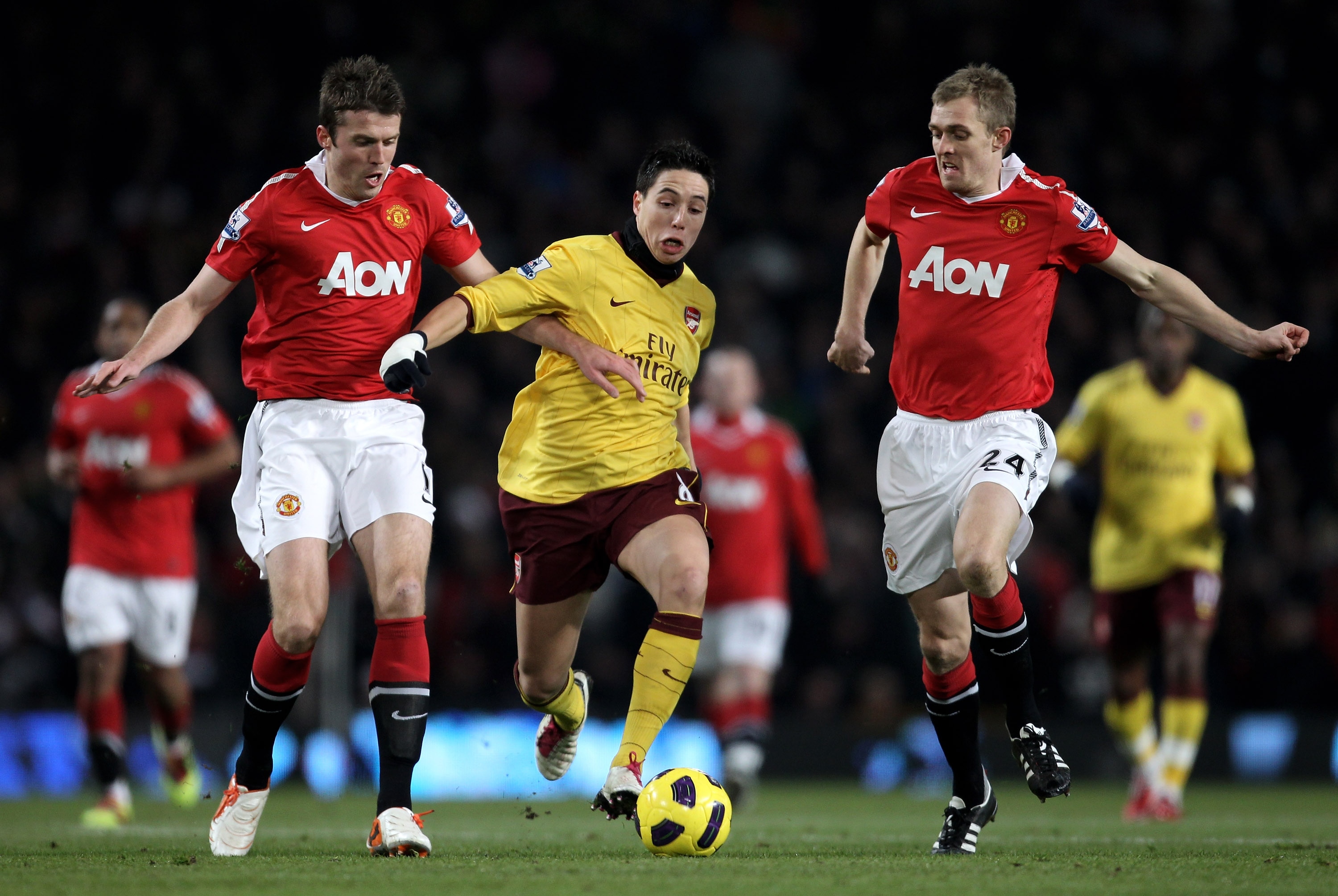 MANCHESTER, ENGLAND - DECEMBER 13:  Samir Nasri of Arsenal competes with Darren Fletcher (R) and Michael Carrick of Manchester United during the Barclays Premier League match between Manchester United and Arsenal at Old Trafford on December 13, 2010 in Ma