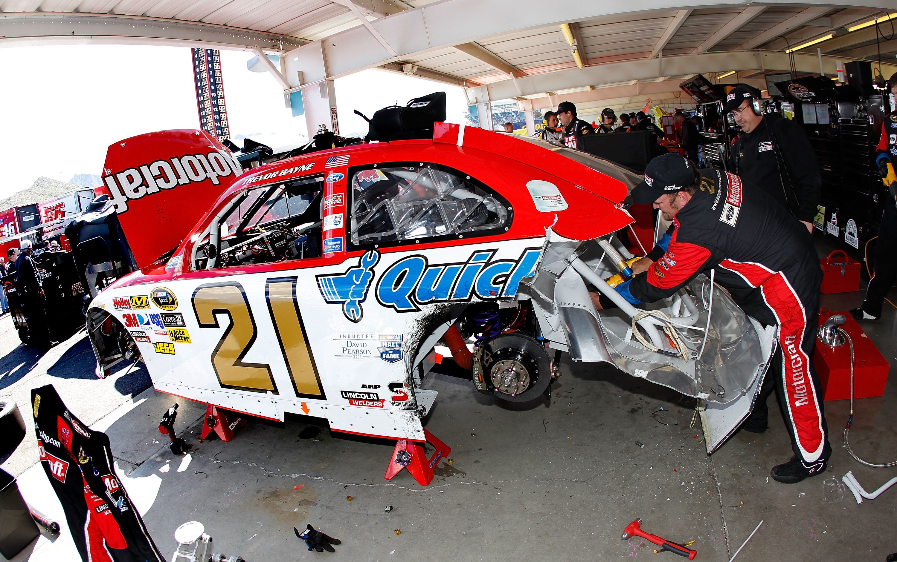 AVONDALE, AZ - FEBRUARY 27:  Crew members work on the car Trevor Bayne, driver of the #21 Motorcraft/Quick Lane Ford, after Bayne crashed during the NASCAR Sprint Cup Series Subway Fresh Fit 500 at Phoenix International Raceway on February 27, 2011 in Avo