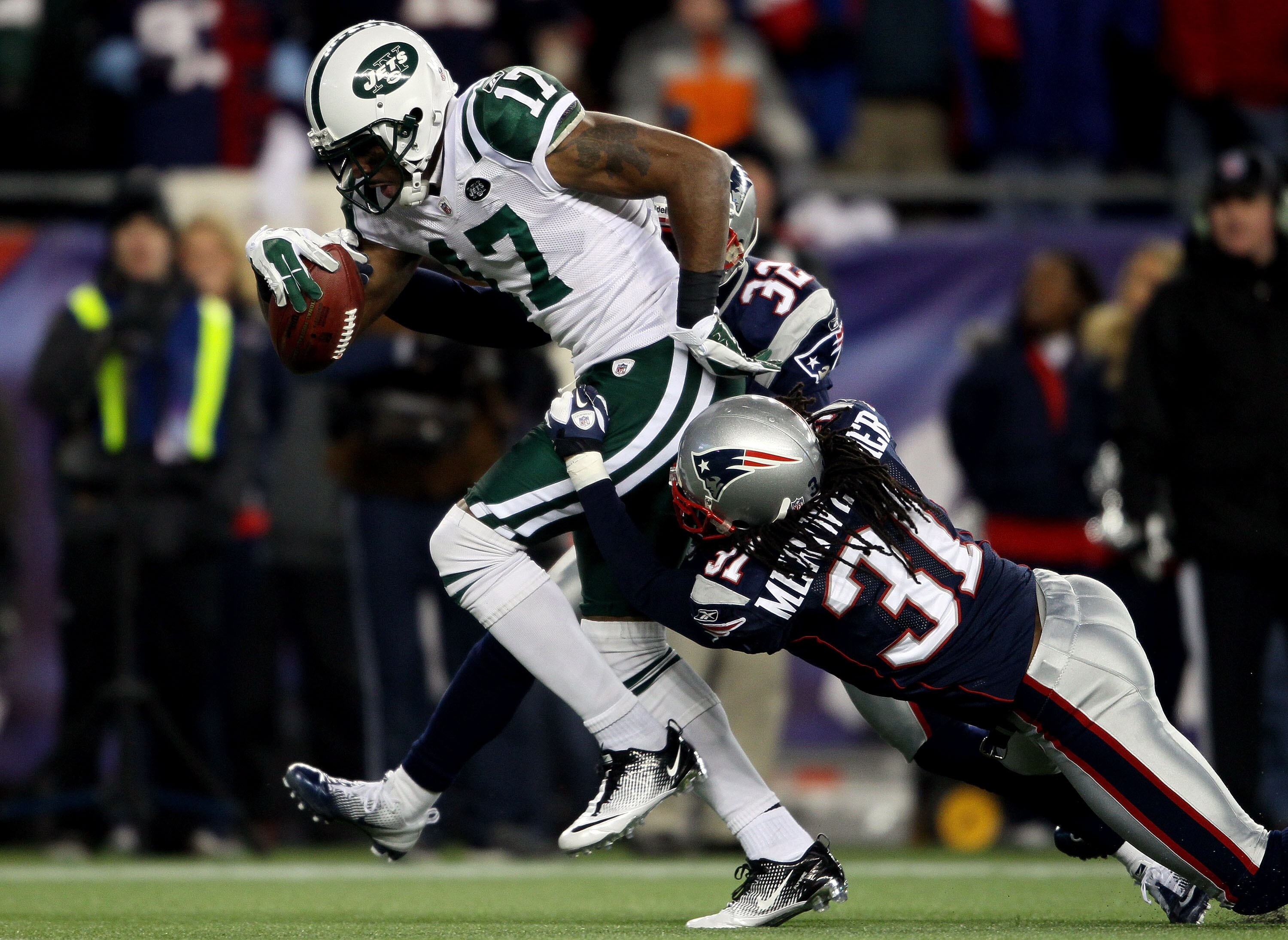 FOXBORO, MA - JANUARY 16:  Braylon Edwards #17 of the New York Jets scores a second quarter touchdown as Devin McCourty #32 and Brandon Meriweather #31 of the New England Patriots attempt to tackle during their 2011 AFC divisional playoff game at Gillette
