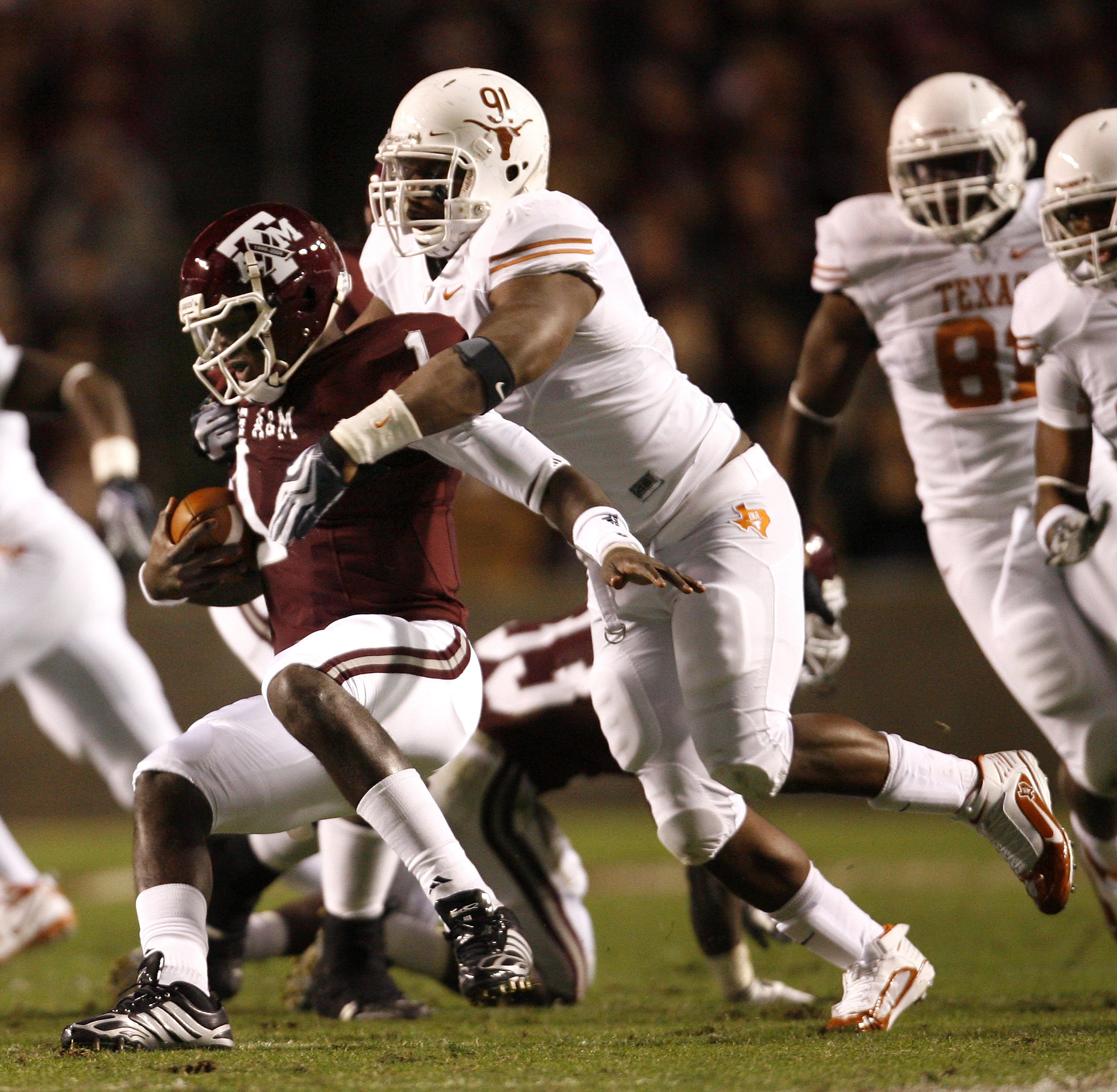 COLLEGE STATION, TX - NOVEMBER 26: Defensive tackle Kheeston Randall #91 of the Texas Longhorns sacks quarterback Jerrod Johnson #1 of the Texas A&M Aggies for a loss in the first half at Kyle Field on November 26, 2009 in College Station, Texas. The Long COLLEGE STATION, TX - NOVEMBER 26: Defensive tackle Kheeston Randall #91 of the Texas Longhorns sacks quarterback Jerrod Johnson #1 of the Texas A&M Aggies for a loss in the first half at Kyle Field on November 26, 2009 in College Station, Texas. The Long