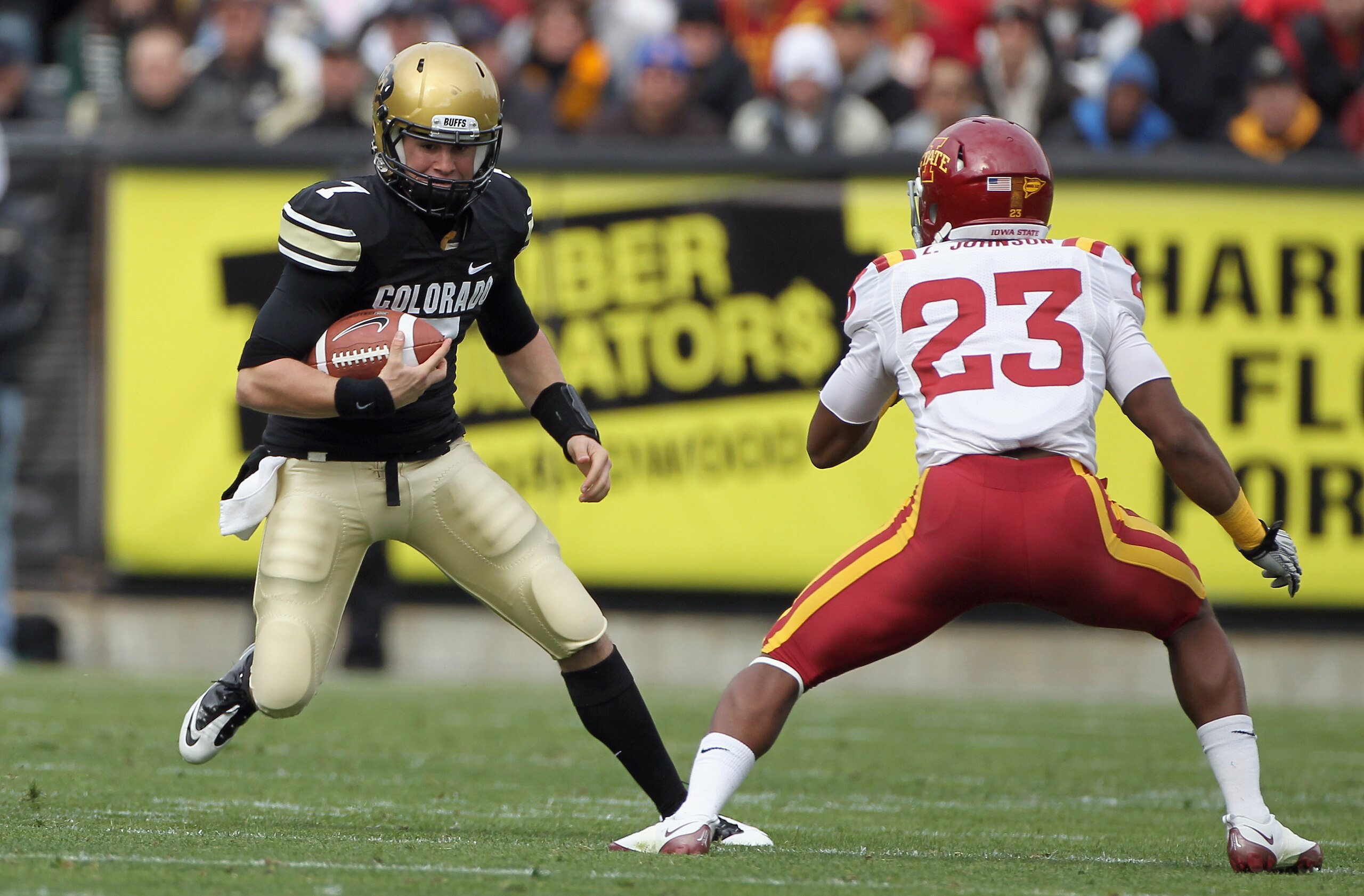 BOULDER, CO - NOVEMBER 13:  Quarterback Cody Hawkins #7 of the Colorado Buffaloes scrambles as Leonard Johnson #23 of the Iowa State Cyclones defends at Folsom Field on November 13, 2010 in Boulder, Colorado. Colorado defeated Iowa State 34-14.  (Photo by