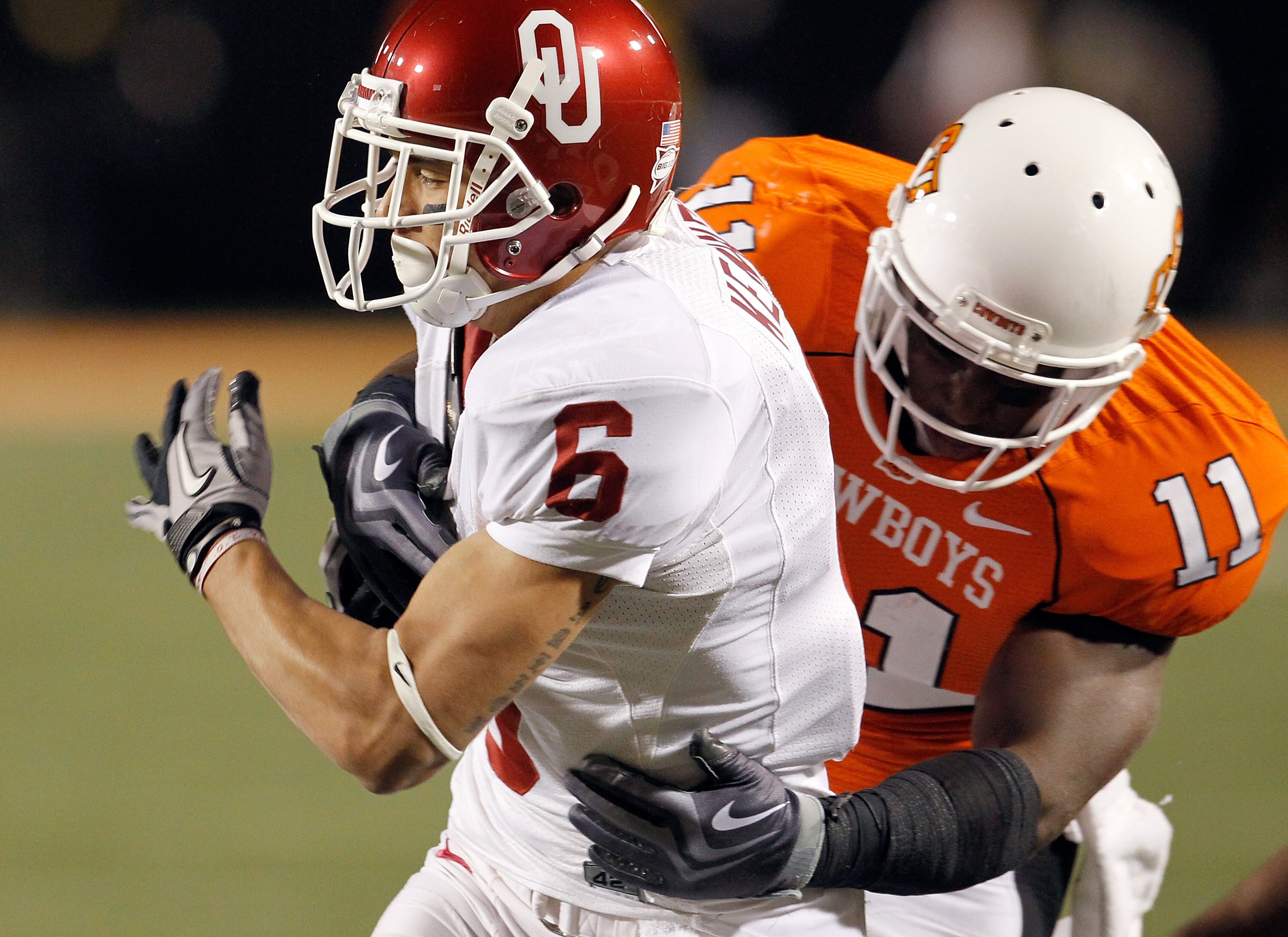 STILLWATER, OK - NOVEMBER 27: Wide receiver Cameron Kenney #6 of the Oklahoma Sooners carries the ball against linebacker Shaun Lewis #11 of the Oklahoma State Cowboys at Boone Pickens Stadium on November 27, 2010 in Stillwater, Oklahoma. The Sooners be STILLWATER, OK - NOVEMBER 27: Wide receiver Cameron Kenney #6 of the Oklahoma Sooners carries the ball against linebacker Shaun Lewis #11 of the Oklahoma State Cowboys at Boone Pickens Stadium on November 27, 2010 in Stillwater, Oklahoma. The Sooners be
