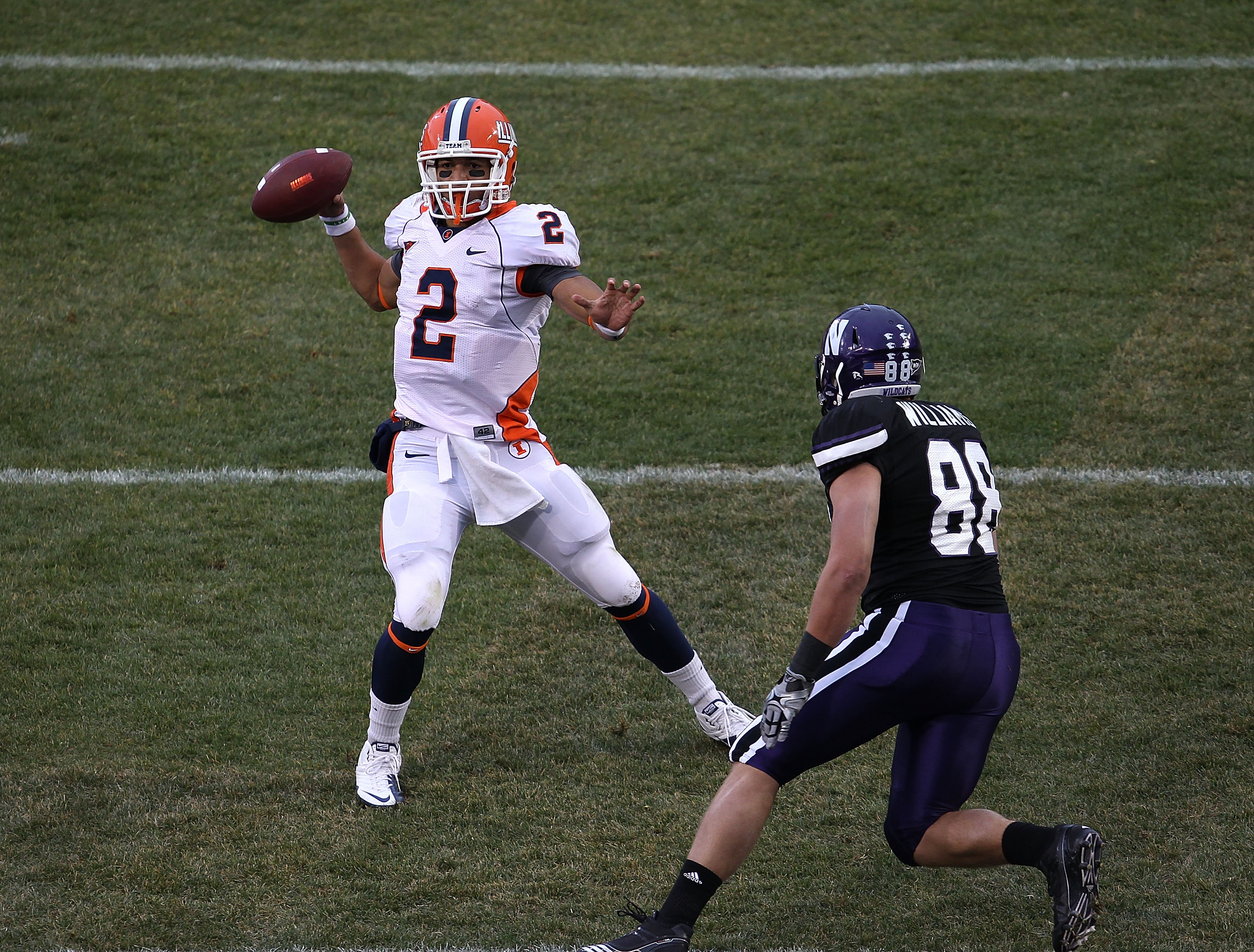 CHICAGO, IL - NOVEMBER 20: Nathan Scheelhasse #2 of the Illinois Fighting Illini throiws a pass as Quentin Williams #88 of the Northwestern Wildcats rushes during a game played at Wrigley Field on November 20, 2010 in Chicago, Illinois. Illinois defeated
