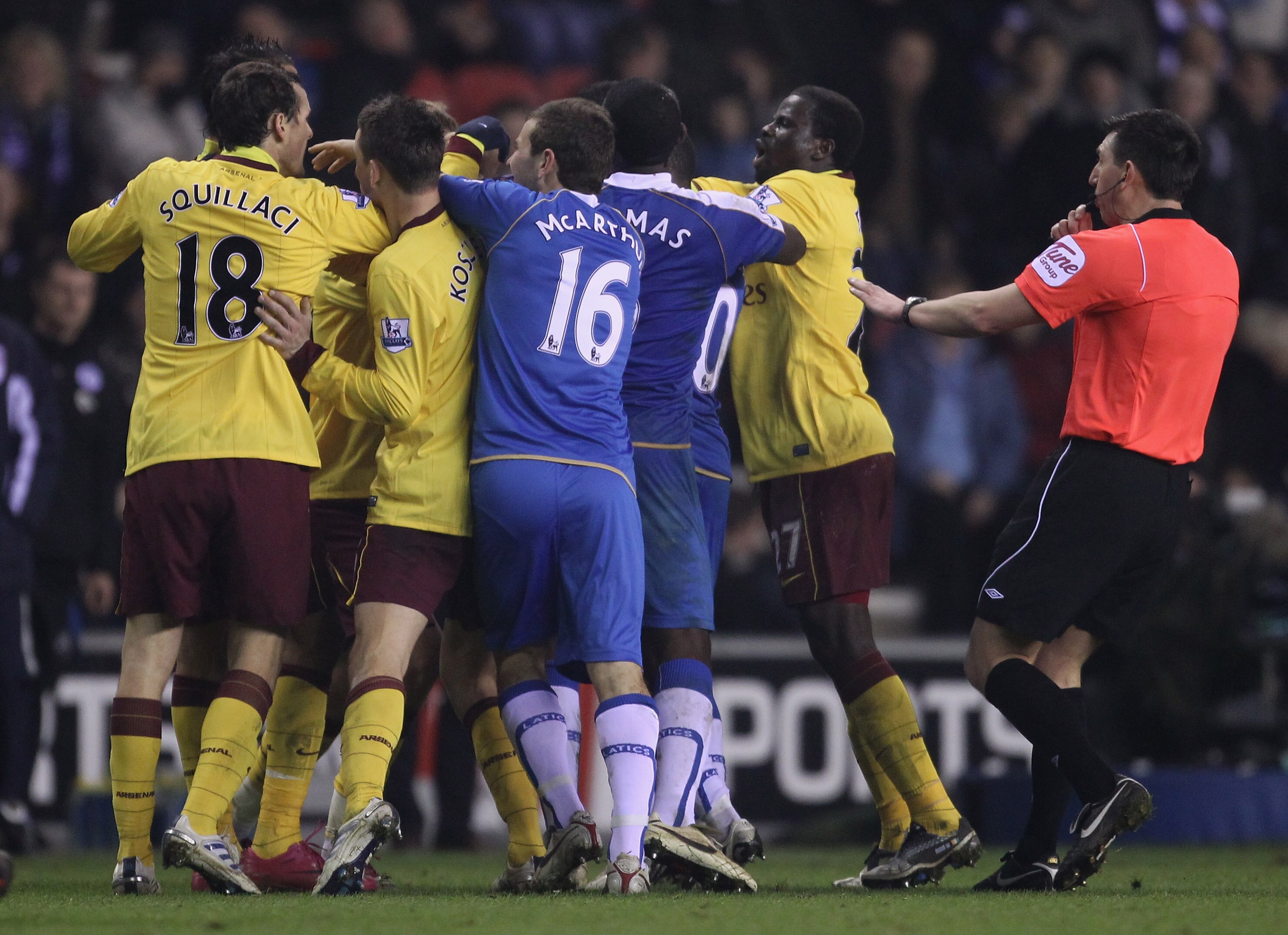 WIGAN, ENGLAND - DECEMBER 29:  Referee Lee Probert attempts to break up players from Wigan Athletic and Arsenal as they clash following an incident between Charles N'Zogbia of Wigan Athletic and Marouane Chamakh of Arsenal during the Barclays Premier Leag