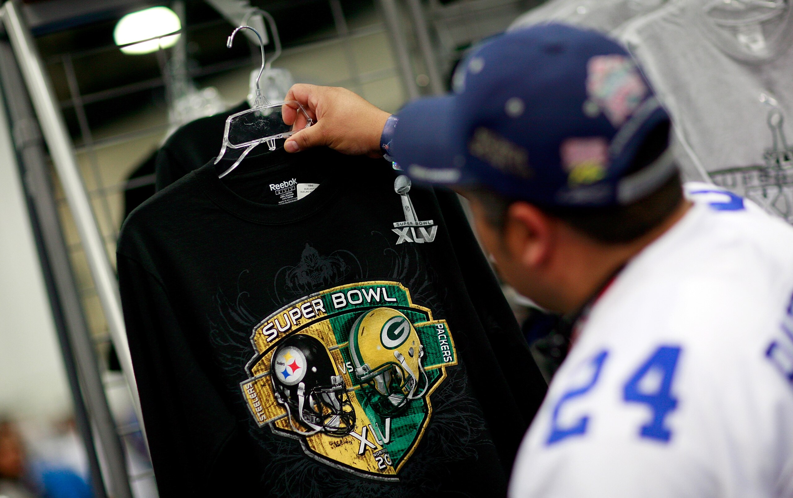 DALLAS, TX - JANUARY 29:  Football fans shop for officially licensed NFL merchandise at the NFL Shop while visiting the NFL Experience exhibit at the Dallas Convention Center on January 29, 2011 in Dallas, Texas. The 850,000 square foot NFL theme park is