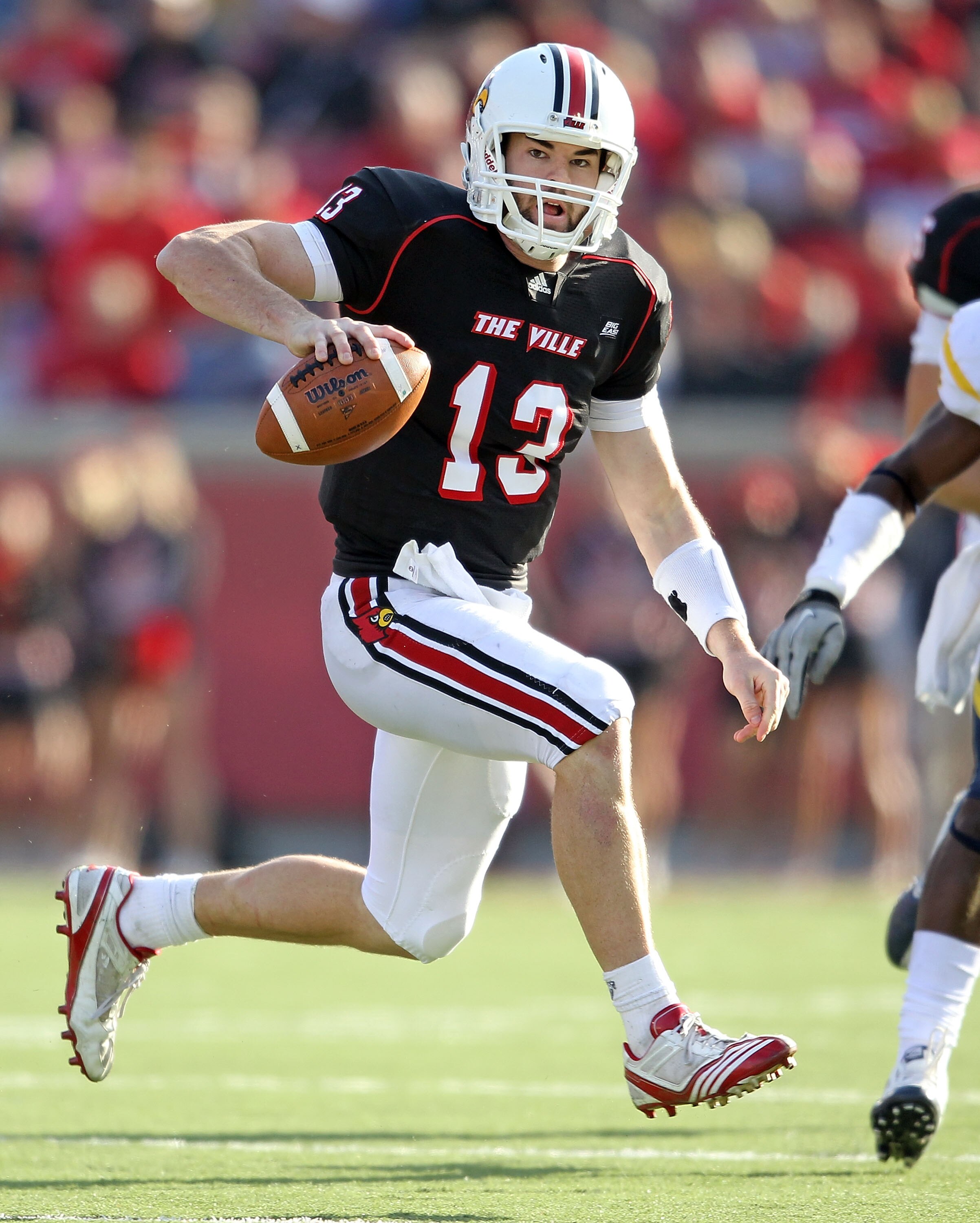 LOUISVILLE, KY - NOVEMBER 20:  Justin Burke #13 of the Louisville Cardinals runs with the ball during the Big East Conference game against the West Virginia Mountaineers at Papa John's Cardinal Stadium on November 20, 2010 in Louisville, Kentucky.  (Photo