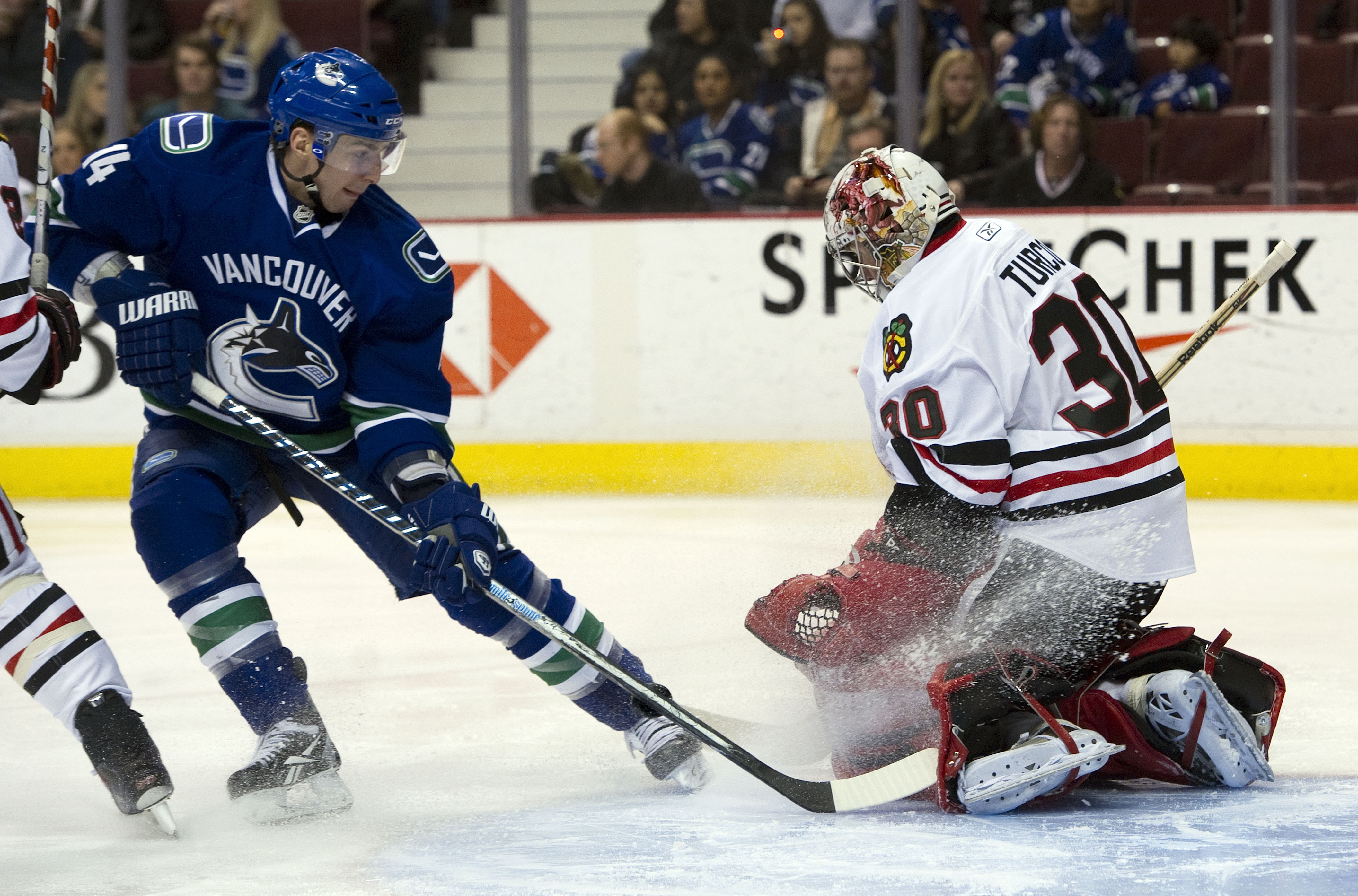 VANCOUVER, CANADA - FEBRUARY 4: Alexandre Burrows #14 of the Vancouver Canucks fails to get a handle on the loose puck after goalie Marty Turco #30 of the Chicago Blackhawks made a pad save during the second period in NHL action on February 04, 2011 at Ro VANCOUVER, CANADA - FEBRUARY 4: Alexandre Burrows #14 of the Vancouver Canucks fails to get a handle on the loose puck after goalie Marty Turco #30 of the Chicago Blackhawks made a pad save during the second period in NHL action on February 04, 2011 at Ro