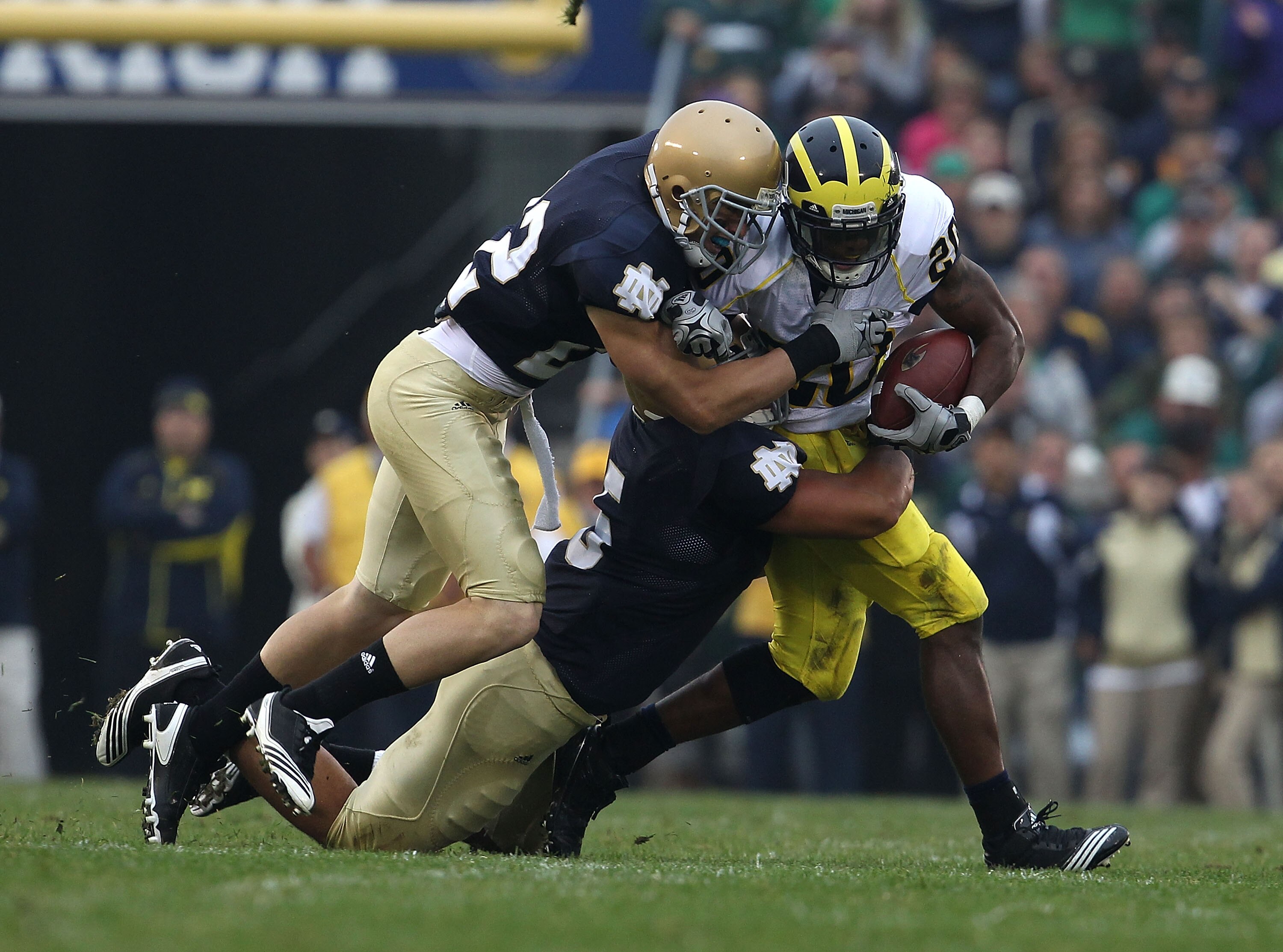 SOUTH BEND, IN - SEPTEMBER 11: Michael Shaw #20 of the Michigan Wolverines is tackled by Manti Te'o #5 and Harrison Smith #22 of the Notre Dame Fighting Irish at Notre Dame Stadium on September 11, 2010 in South Bend, Indiana. Michigan defeated Notre Dame