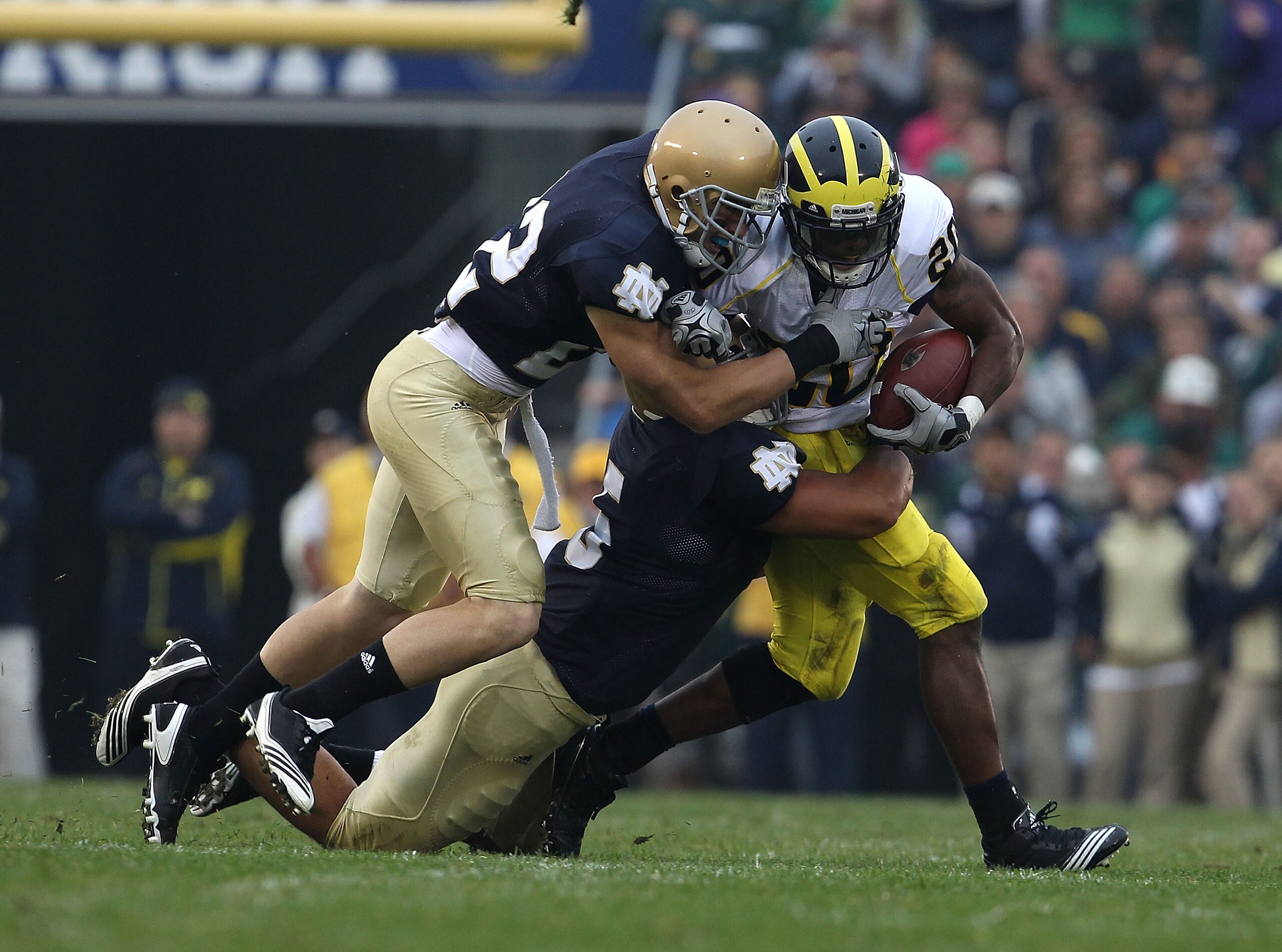 SOUTH BEND, IN - SEPTEMBER 11: Michael Shaw #20 of the Michigan Wolverines is tackled by Manti Te'o #5 and Harrison Smith #22 of the Notre Dame Fighting Irish at Notre Dame Stadium on September 11, 2010 in South Bend, Indiana. Michigan defeated Notre Dame