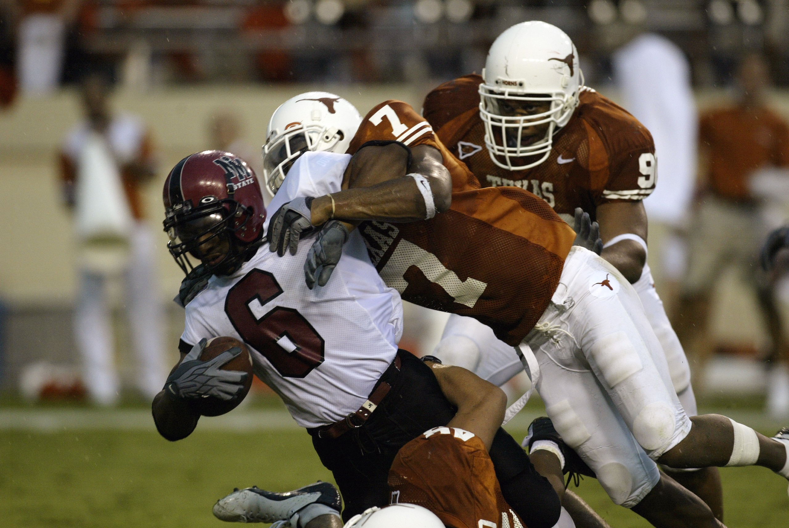 AUSTIN, TX - AUGUST 31:  Safety Michael Huff #7 and defensive tackle Rodrique White #90 of the University of Texas at Austin Longhorns stops Keith Mouton #6 of the New Mexico State University Aggies at Texas Memorial Stadium on August 31, 2003 in Austin,