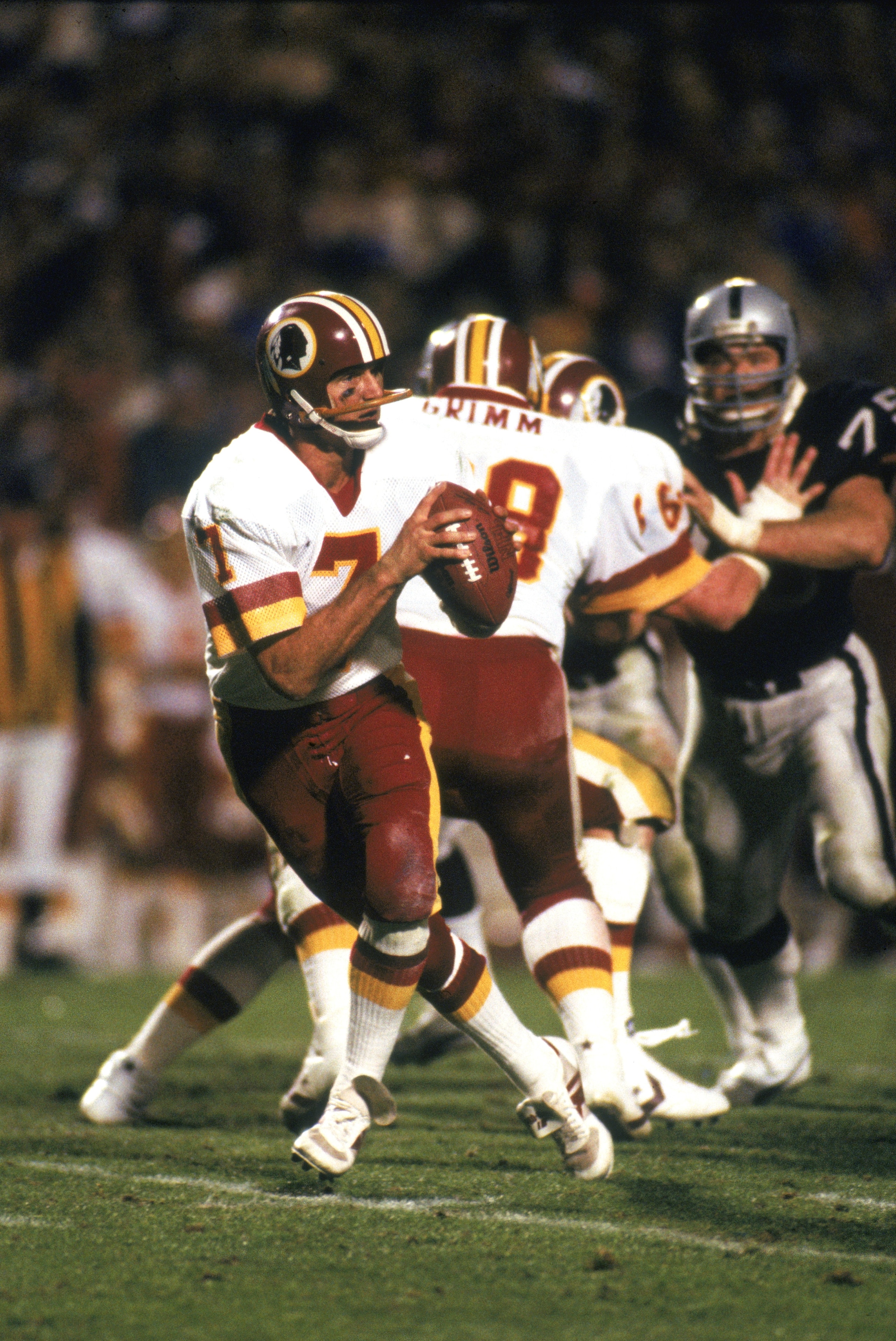 TAMPA, FL - JANUARY 22:  Joe Theismann #7 of the Washington Redskins moves back to pass during Super Bowl XVIII against the Los Angeles Raiders at Tampa Stadium on January 22, 1984 in Tampa, Florida. The Radiers defeated the Redskins 38-9. (Photo by: Gett