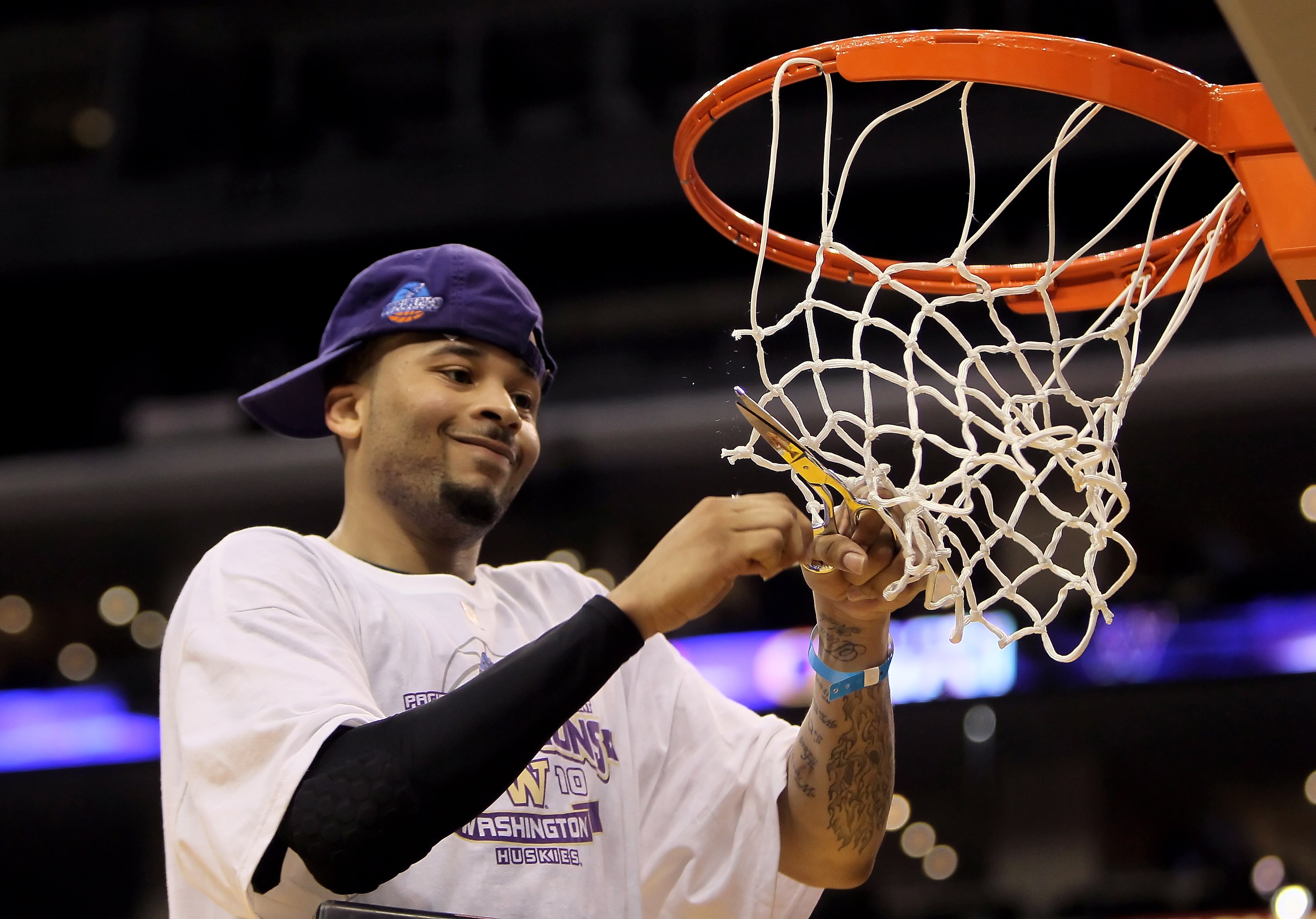 LOS ANGELES, CA - MARCH 13:  Venoy Overton #1 of the Washington Huskies celebrates by cutting down the net following his teams victory over the Cal Golden Bears in the championship game of the Pac-10 Basketball Tournament at Staples Center on March 13, 20