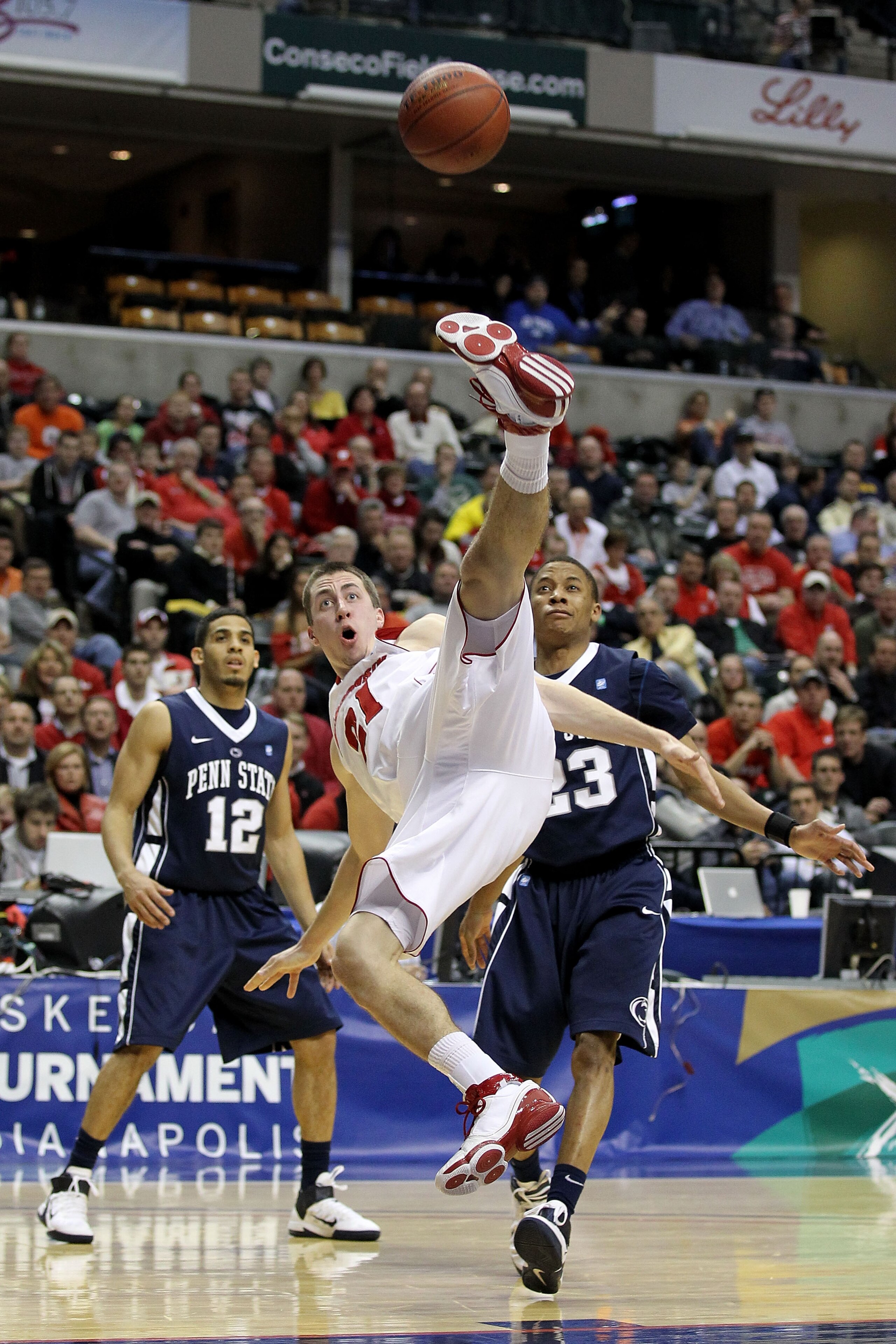 INDIANAPOLIS, IN - MARCH 11:  Josh Gasser #21 of the Wisconsin Badgers falls down after he was fouled going for a rebound against the Penn State Nittany Lions during the quarterfinals of the 2011 Big Ten Men's Basketball Tournament at Conseco Fieldhouse o