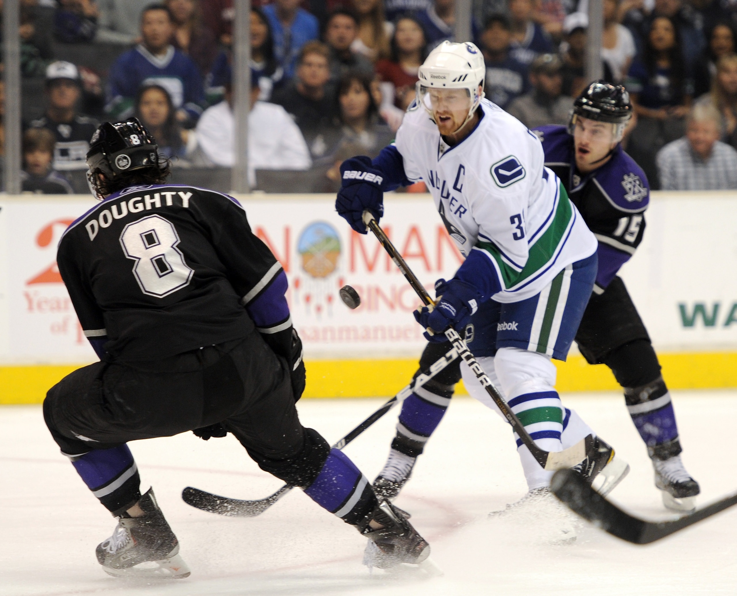 LOS ANGELES, CA - MARCH 05:  Henrik Sedin #33 of the Vancouver Canucks has his shot deflected by Drew Doughty #8 of the Los Angeles Kings at the Staples Center on March 5, 2011 in Los Angeles, California.  (Photo by Harry How/Getty Images)