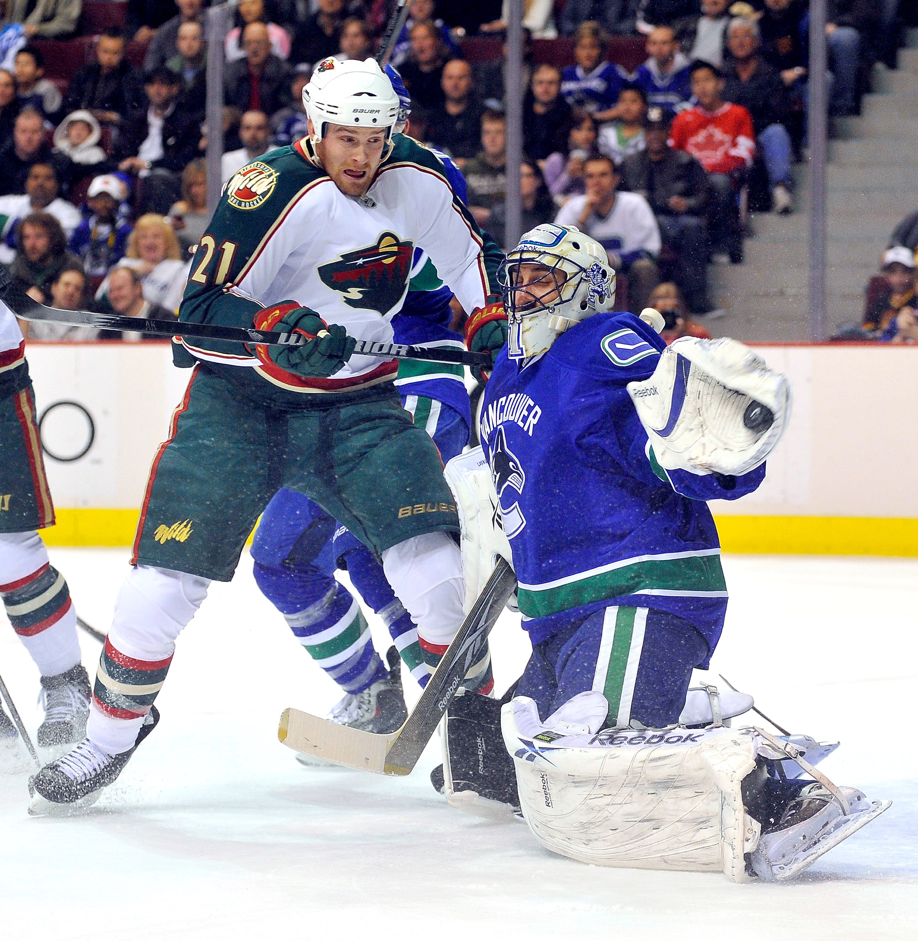 VANCOUVER, CANADA - APRIL 4: Kyle Brodziak #21 of the Minnesota Wild watches goalie Roberto Luongo #1 of the Vancouver Canucks make a glove during the first period of NHL action on April 04, 2010 at General Motors Place in Vancouver, British Columbia, Can VANCOUVER, CANADA - APRIL 4: Kyle Brodziak #21 of the Minnesota Wild watches goalie Roberto Luongo #1 of the Vancouver Canucks make a glove during the first period of NHL action on April 04, 2010 at General Motors Place in Vancouver, British Columbia, Can
