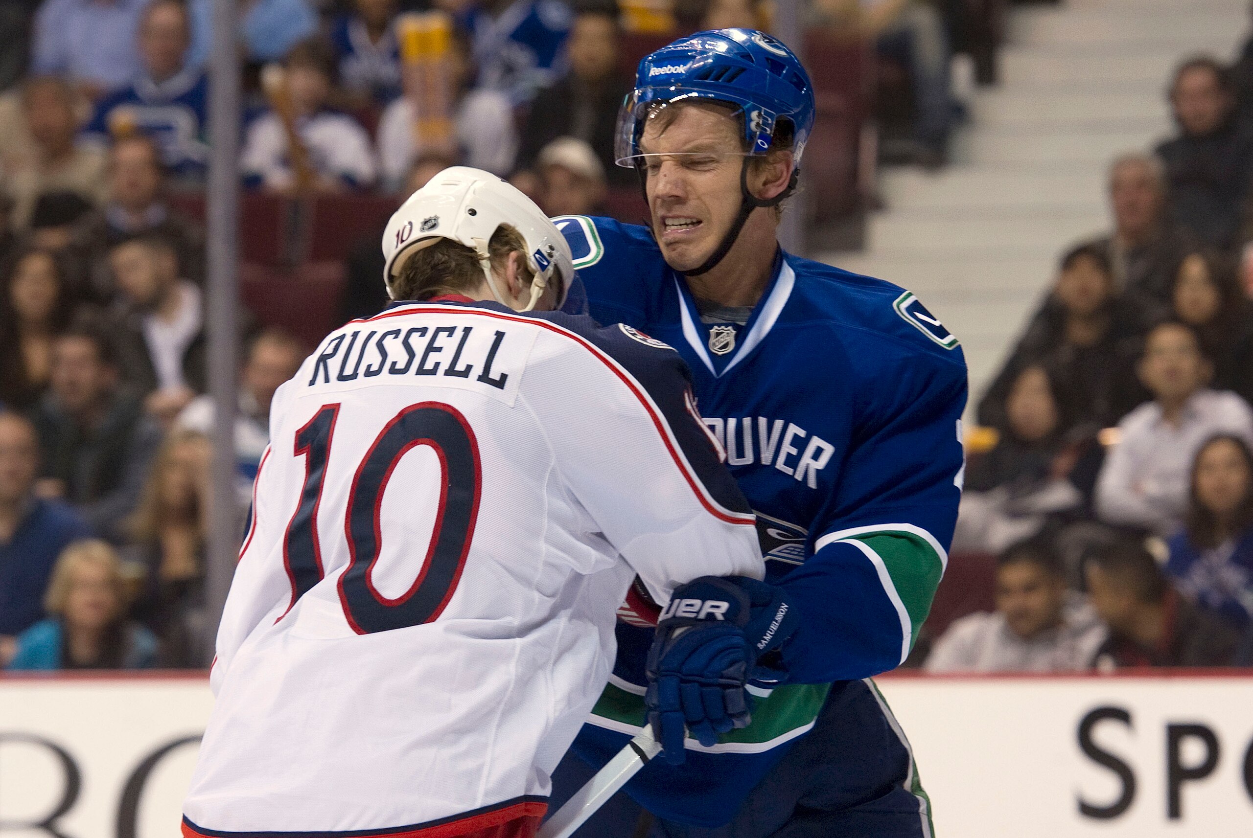 VANCOUVER, CANADA - MARCH 1: Mikael Samuelsson #26 of the Vancouver Canucks punched Kris Russell #10 of the Columbus Blue Jackets while battling in front of the net during the second period in NHL action on March 01, 2011 at Rogers Arena in Vancouver, Bri