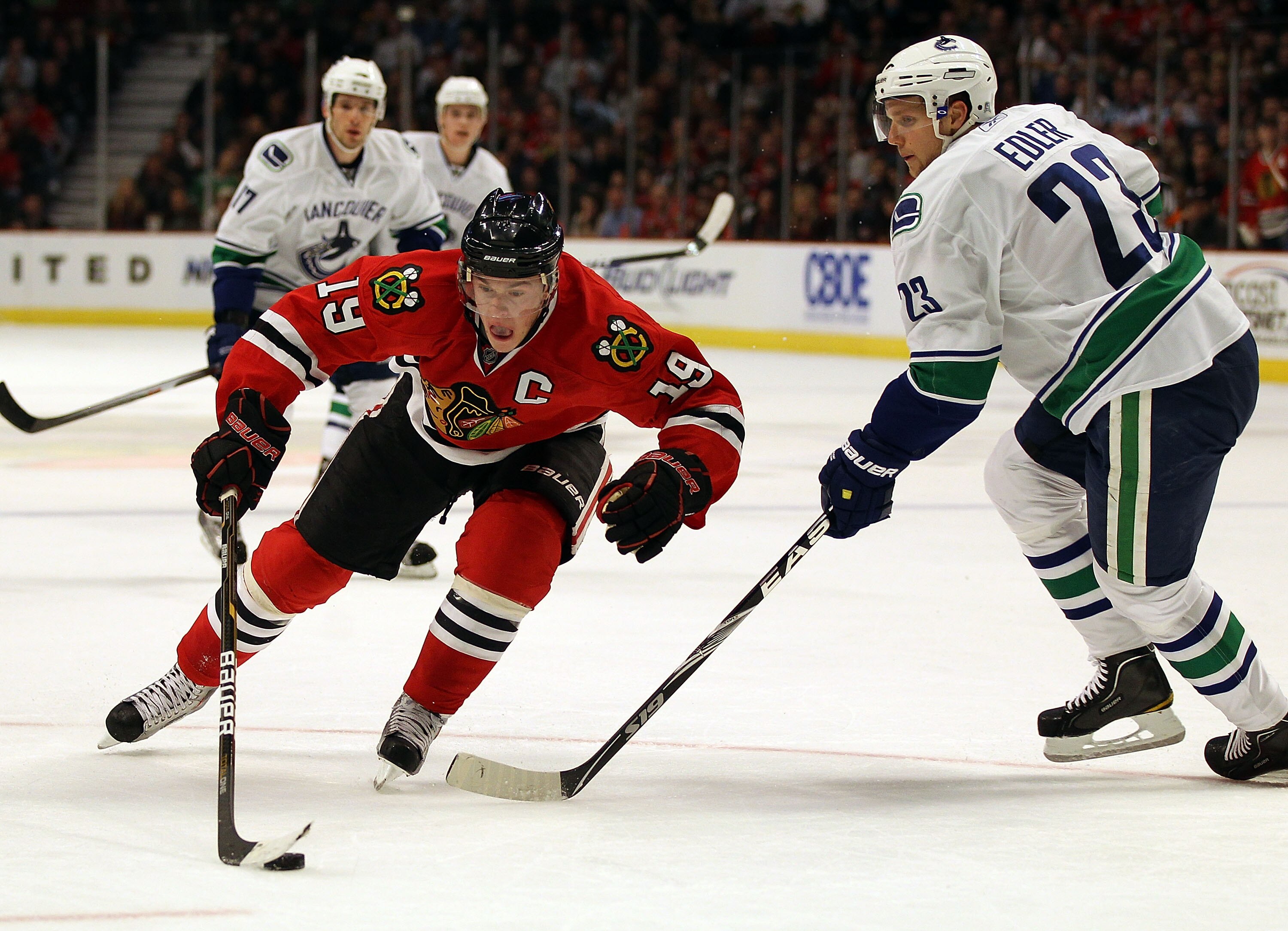 CHICAGO, IL - DECEMBER 03: Jonathan Toews #19 of the Chicago Blackhawks controls the puck against Alexander Edler #23 of the Vancouver Canucks at the United Center on December 3, 2010 in Chicago, Illinois. The Canucks defeated the Blackhawks 3-0. (Photo CHICAGO, IL - DECEMBER 03: Jonathan Toews #19 of the Chicago Blackhawks controls the puck against Alexander Edler #23 of the Vancouver Canucks at the United Center on December 3, 2010 in Chicago, Illinois. The Canucks defeated the Blackhawks 3-0. (Photo