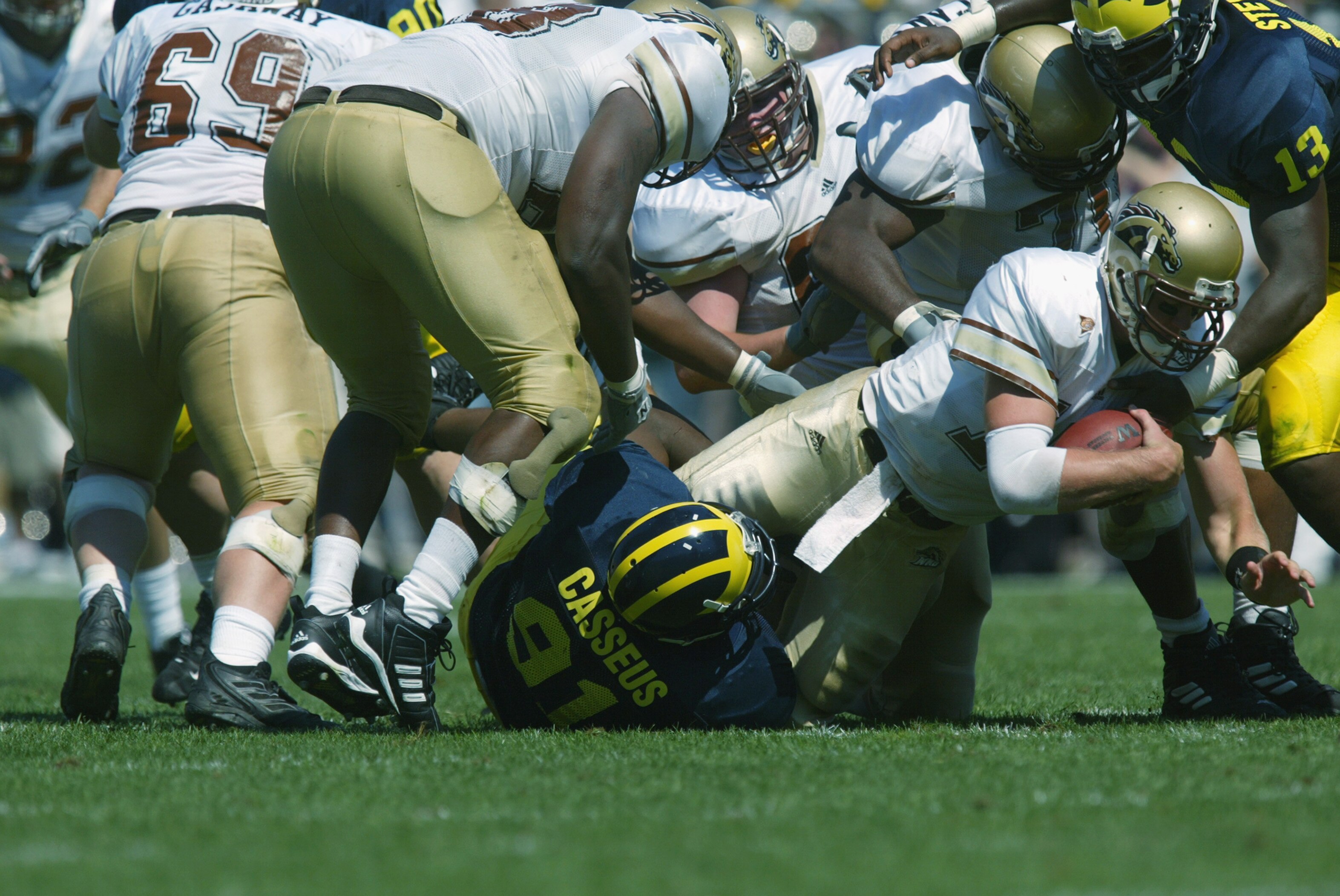 ANN ARBOR, MI - SEPTEMBER 7:  Quarterback Jon Drach #19 of the Western Michigan Broncos gets sacked by Emmanuel Casseus #91 of the University of Michigan Wolverines during the first half of play on September 7, 2002 at Michigan Stadium in Ann Arbor, Michi