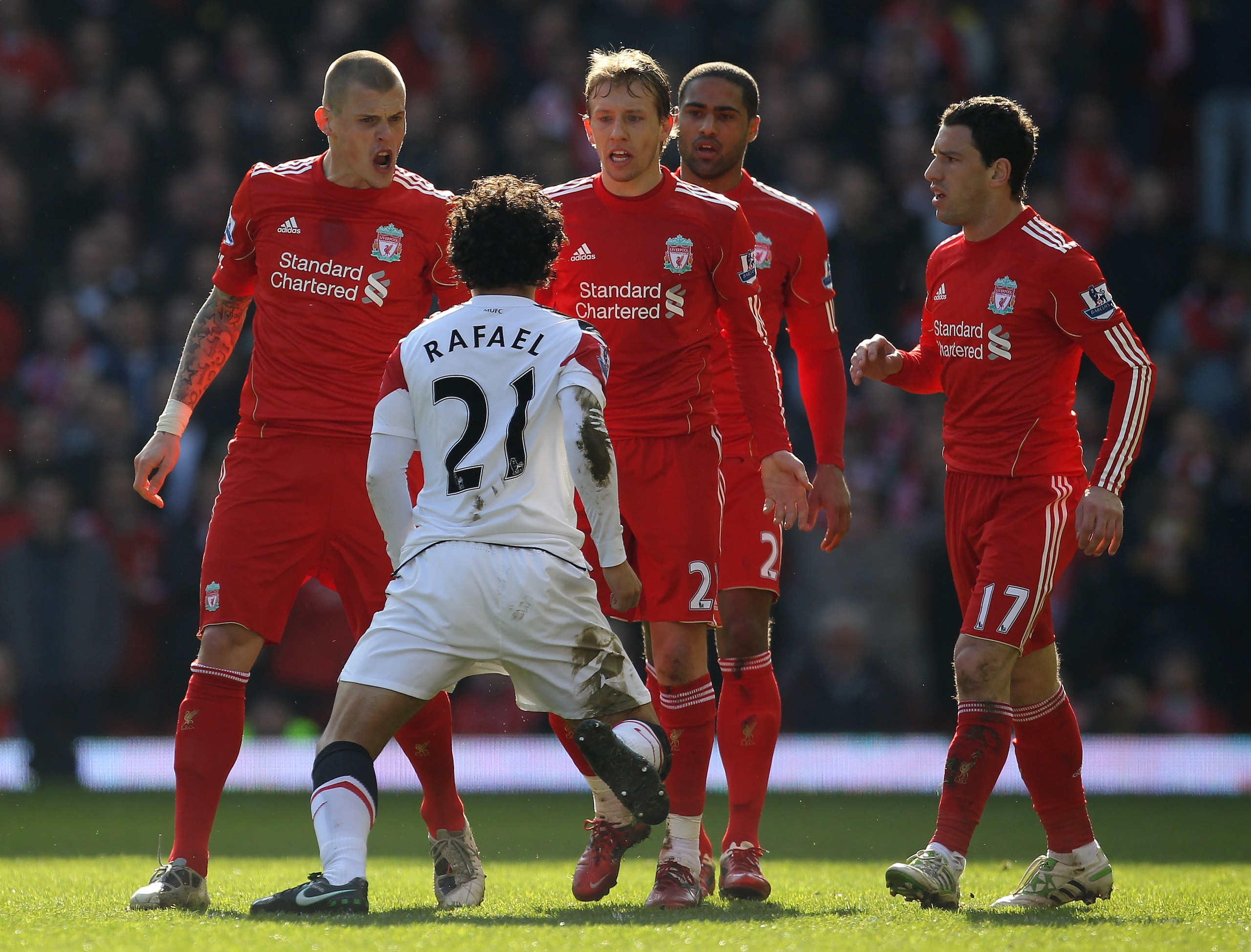 LIVERPOOL, ENGLAND - MARCH 06:  Rafael of Manchester United is confronted by Martin Skrtel (L) and Lucas of Liverpool during the Barclays Premier League match between Liverpool and Manchester United at Anfield on March 6, 2011 in Liverpool, England.  (Pho