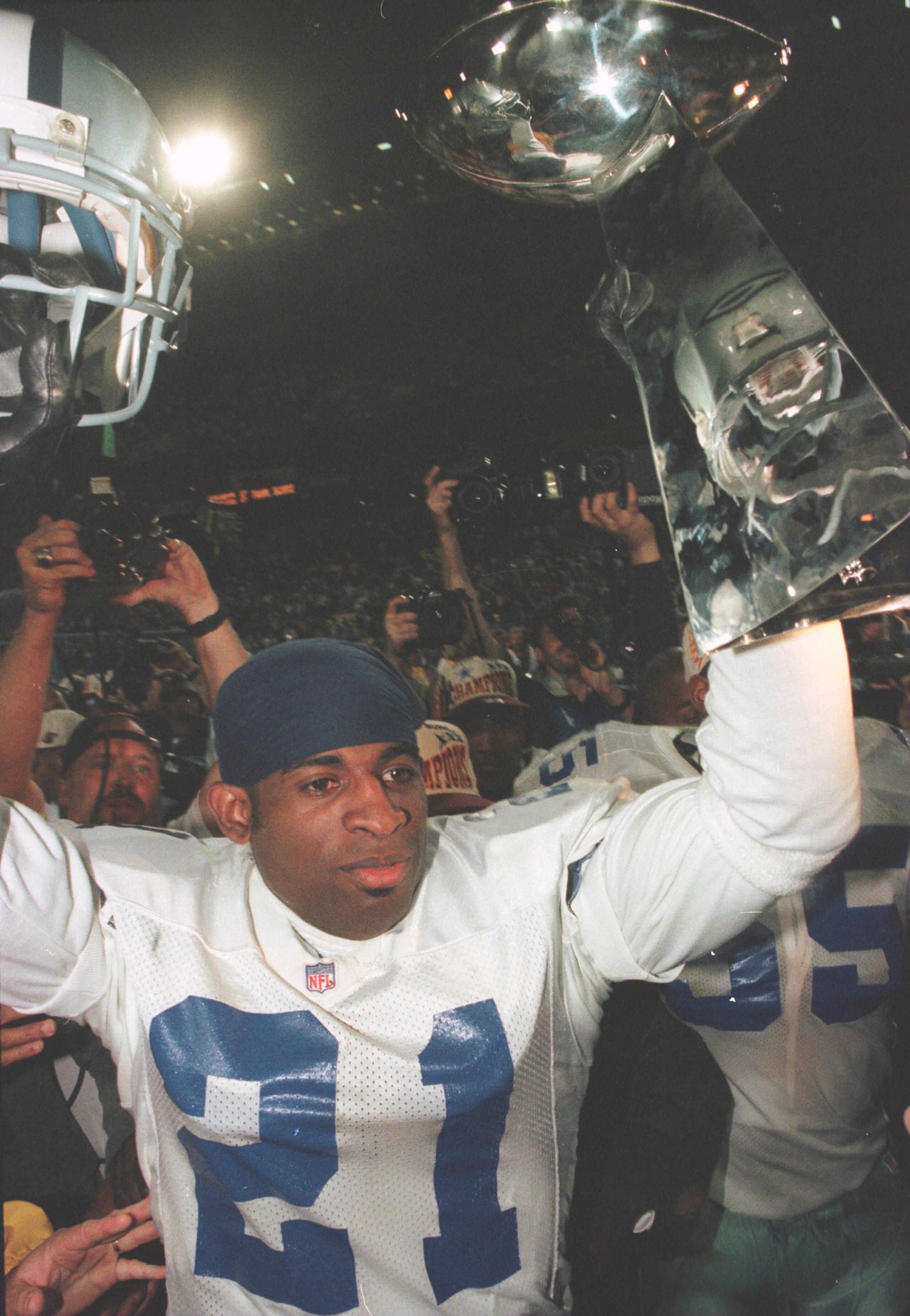 28 Jan 1996: Cornerback Deion Sanders #21 of the Dallas Cowboys holds up the Vince Lombardi Trophy following the Cowboys 27-17 victory over the Pittsburgh Steelers in Super Bowl XXX at Sun Devil Stadium in Tempe, Arizona.