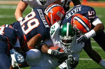 CHAMPAIGN, IL - OCTOBER 10: Walter Aikens #15 and Michael Buchanan #99 of the Illinois Fighting Illini tackle Caulton Ray #24 of the Michigan State Spartans on October 10, 2009 at Memorial Stadium at the University of Illinois in Champaign, Illinois. Mich