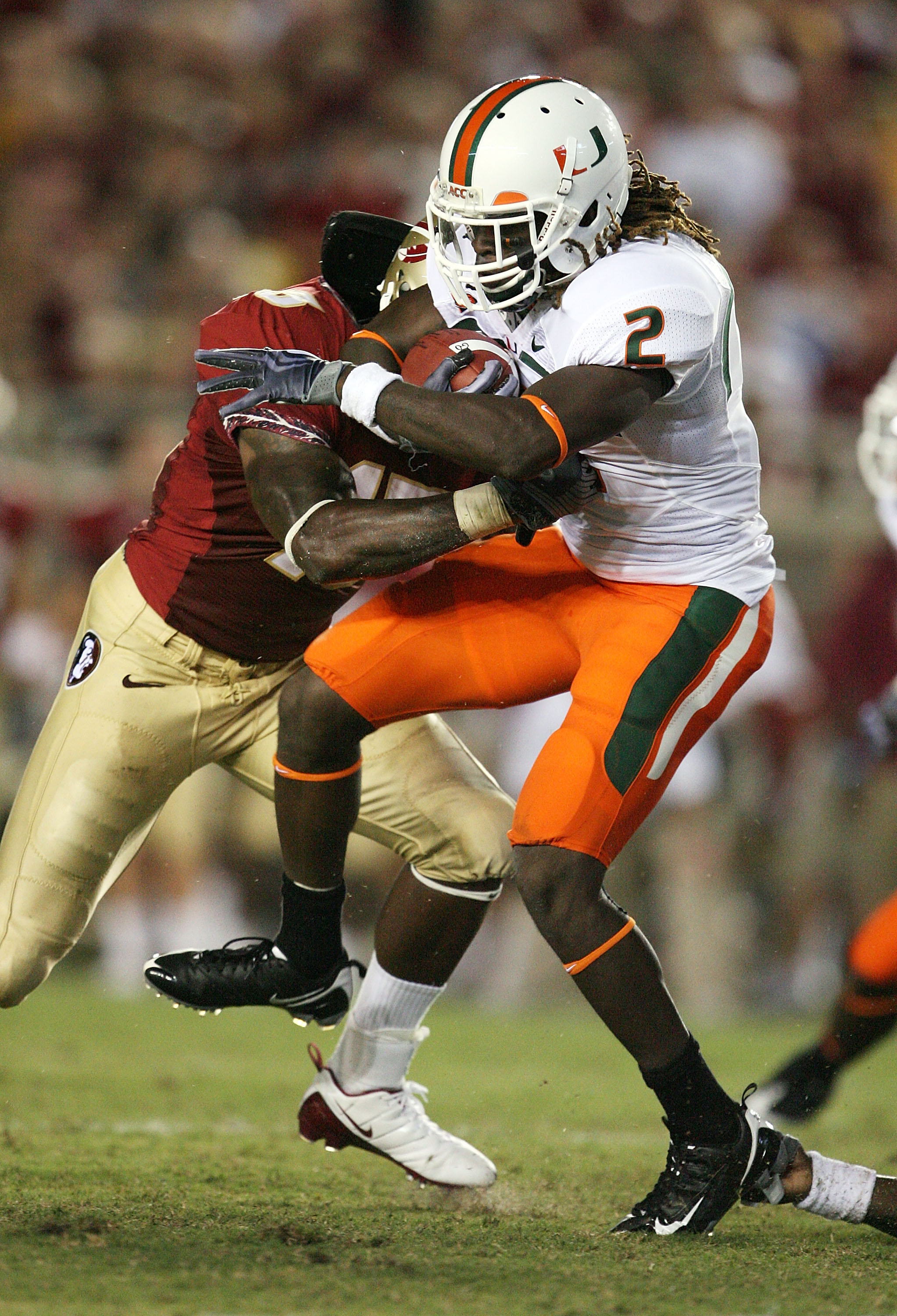 TALLAHASSEE, FL - SEPTEMBER 07:  Running back Graig Cooper #2 of the Miami Hurricanes is brought down by linebacker Mister Alexander #16 of the Florida State Seminoles at Doak Campbell Stadium on September 7, 2009 in Tallahassee, Florida.  (Photo by Doug