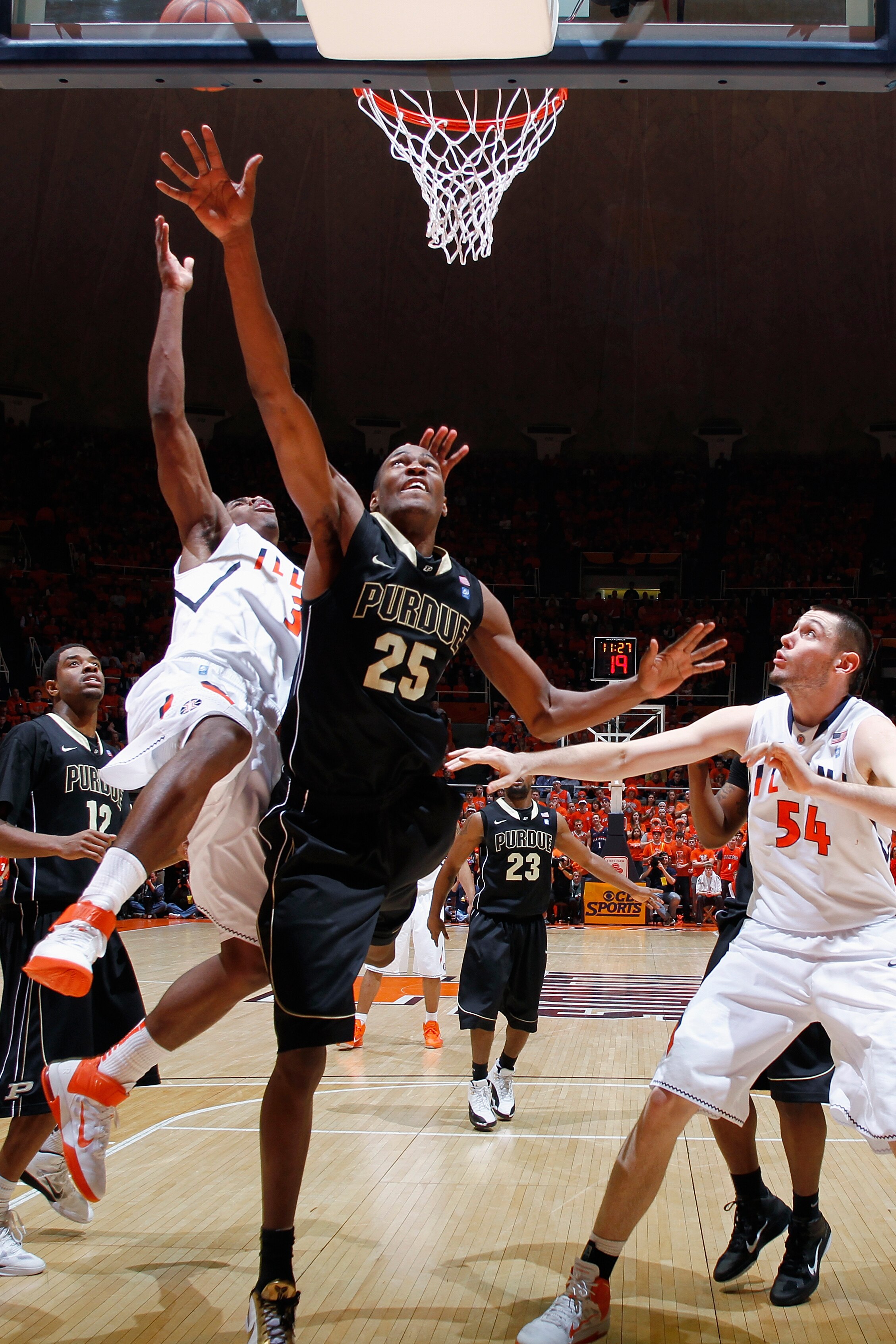 CHAMPAIGN, IL - FEBRUARY 13: JaJuan Johnson #25 of the Purdue Boilermakers goes to the basket against Brandon Paul #3 and Mike Tisdale #54 of the Illinois Fighting Illini at Assembly Hall on February 13, 2011 in Champaign, Illinois. Purdue defeated Illino