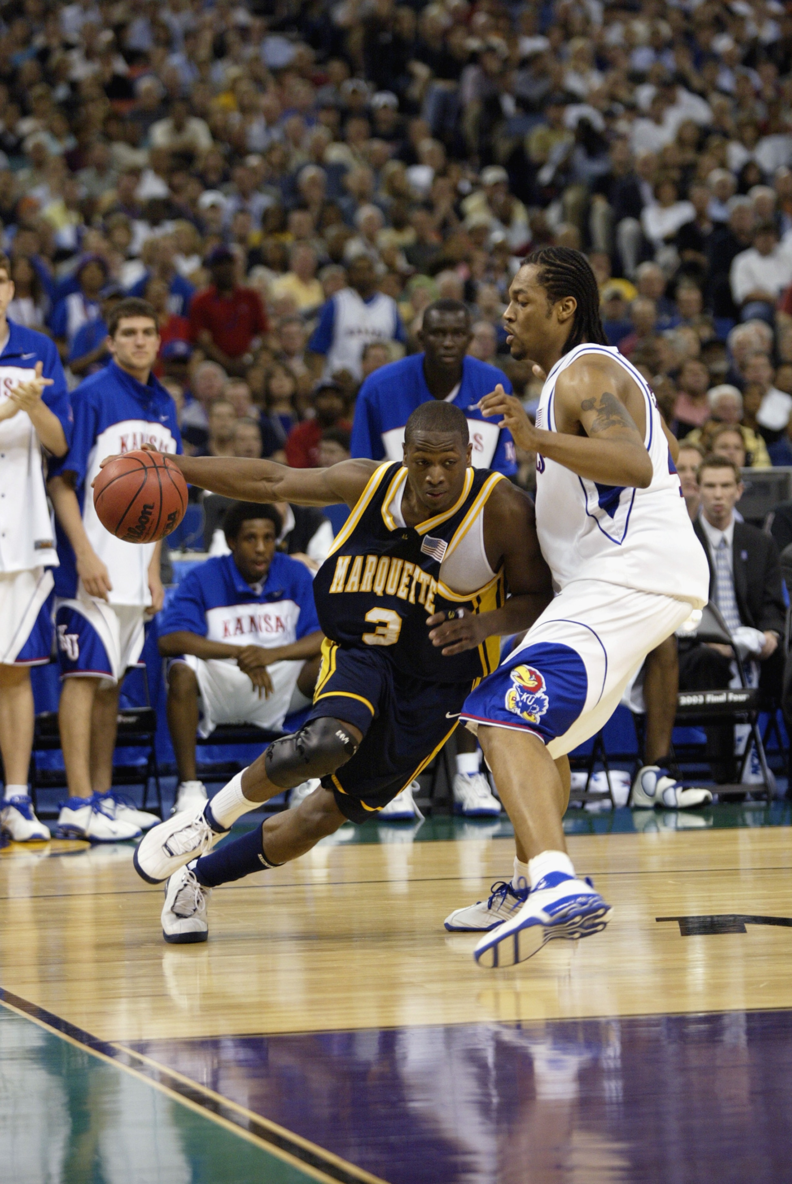 NEW ORLEANS - APRIL 5:  Dwyane Wade #3 of Marquette University Golden Eagles drives around Jeff Graves #42 of the University of Kansas Jayhawks during the semifinal round of the NCAA Final Four Tournament at the Louisiana Superdome on April 5, 2003 in New