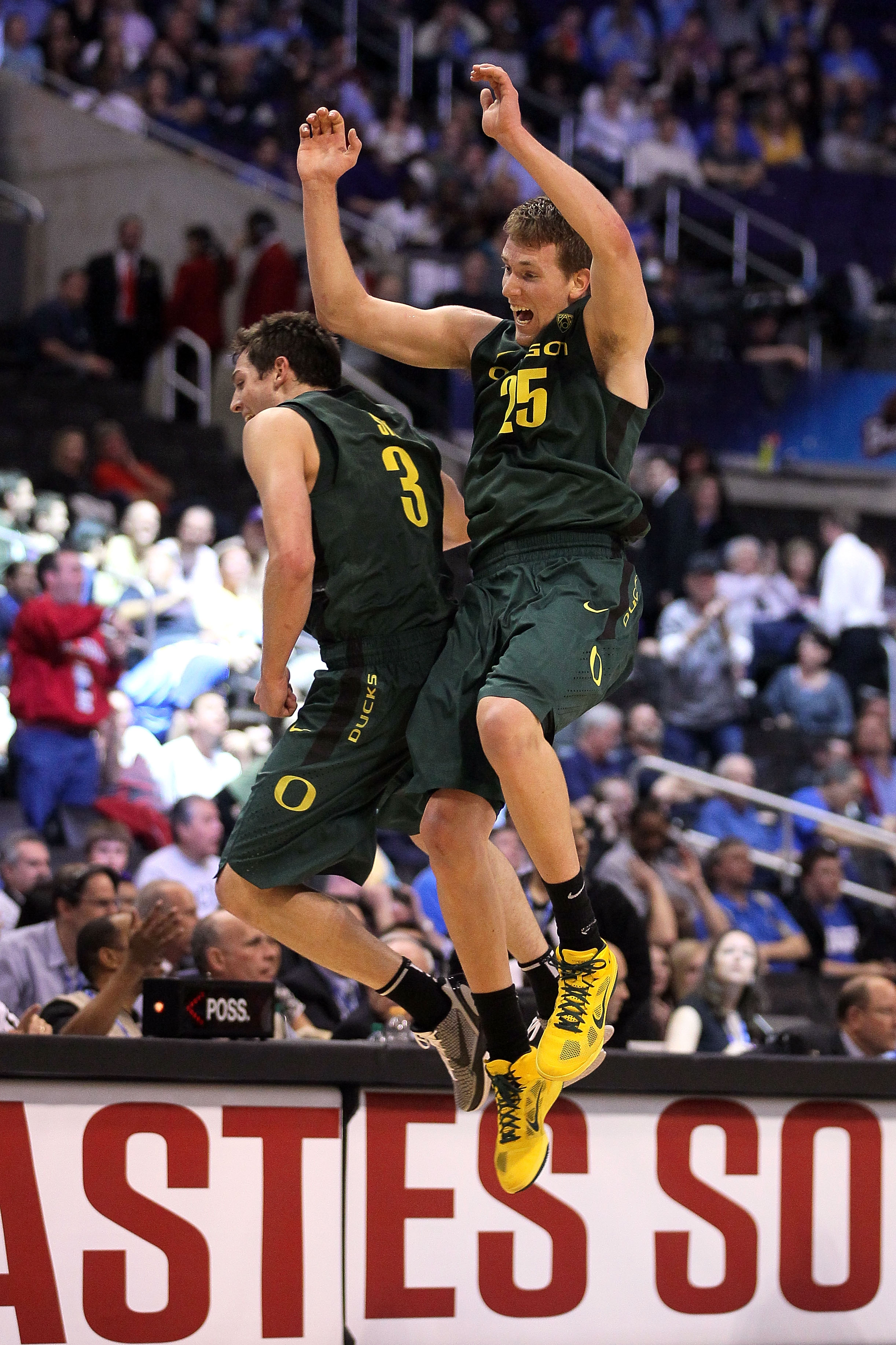 LOS ANGELES, CA - MARCH 10:  Garrett Sim #3 and E.J. Singler #25 of the Oregon Ducks celebrate late in the first quarter while taking on the UCLA Bruins in the quarterfinals of the 2011 Pacific Life Pac-10 Men's Basketball Tournament at Staples Center on