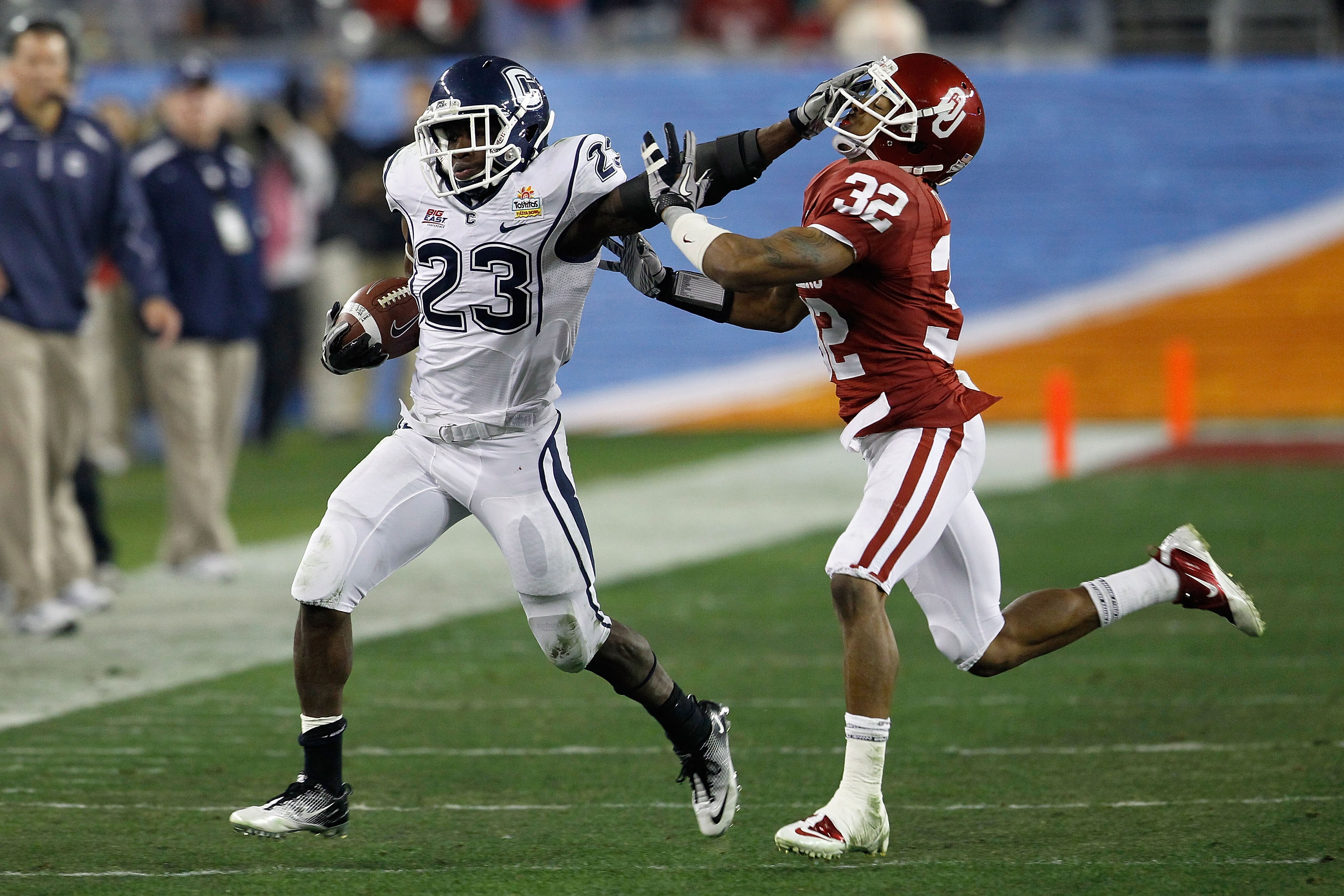 GLENDALE, AZ - JANUARY 01: Jordan Todman #23 of the Connecticut Huskies stiff arms Jamell Fleming #32 of the Oklahoma Sooners in the second quarter during the Tostitos Fiesta Bowl at the Universtity of Phoenix Stadium on January 1, 2011 in Glendale, Ariz GLENDALE, AZ - JANUARY 01: Jordan Todman #23 of the Connecticut Huskies stiff arms Jamell Fleming #32 of the Oklahoma Sooners in the second quarter during the Tostitos Fiesta Bowl at the Universtity of Phoenix Stadium on January 1, 2011 in Glendale, Ariz