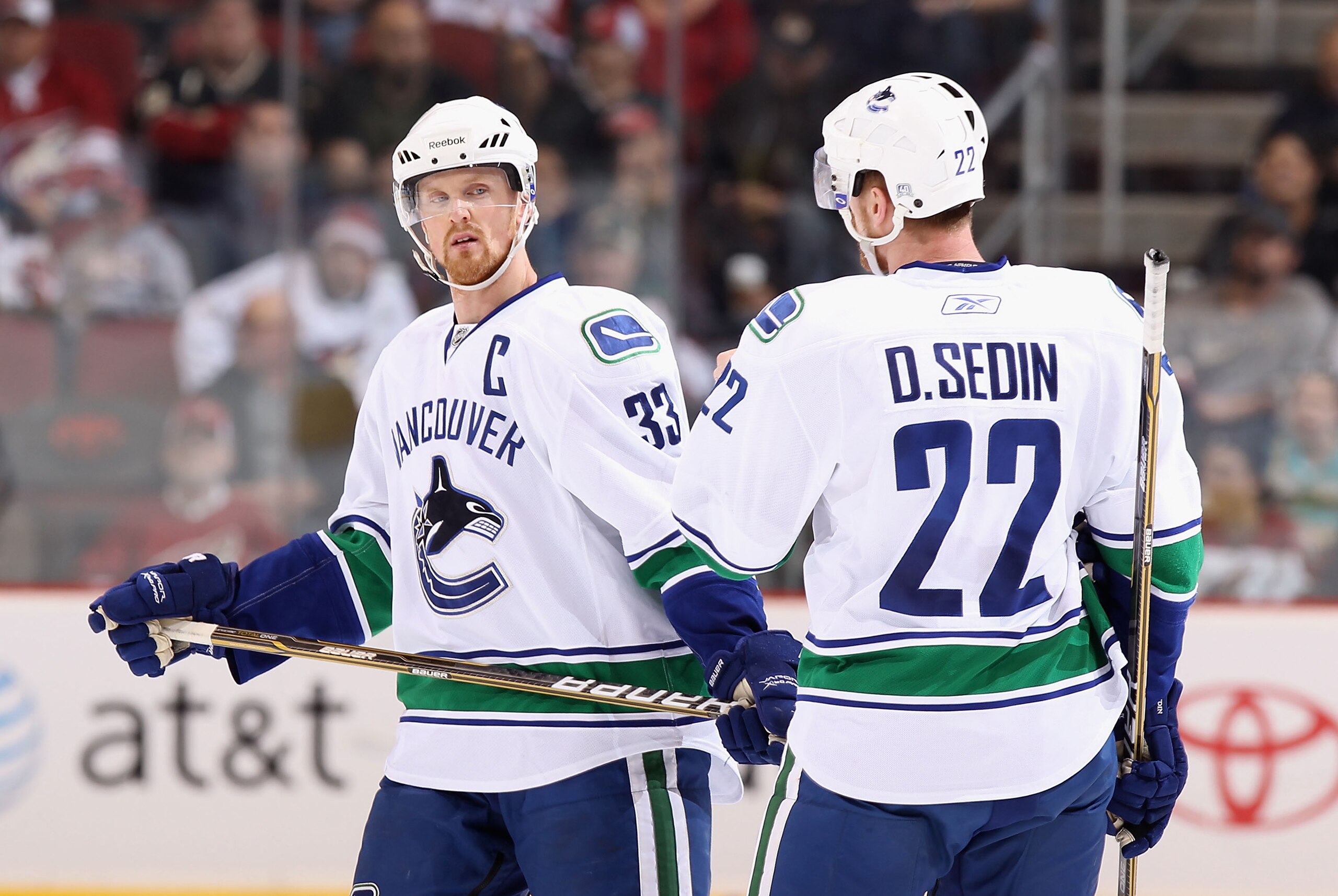 GLENDALE, AZ - MARCH 08:  Henrik Sedin #33 and Daniel Sedin #22 of the Vancouver Canucks talk during the NHL game against the Phoenix Coyotes at Jobing.com Arena on March 8, 2011 in Glendale, Arizona. The Canucks defeated the Coyotes 4-3 in overtime. (Pho