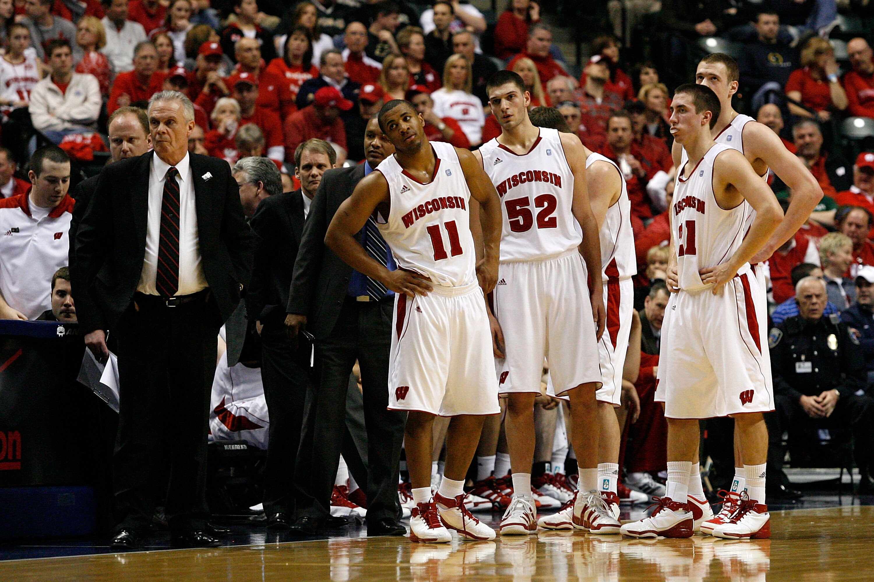 INDIANAPOLIS, IN - MARCH 11:  Head coach Bo Ryan of the Wisconsin Badgers and players Jordan Taylor #11, Keaton Nankivil #52 and Josh Gasser #21 look on as the referee s stand at the scorer's table against the Penn State Nittany Lions during the quarterfi