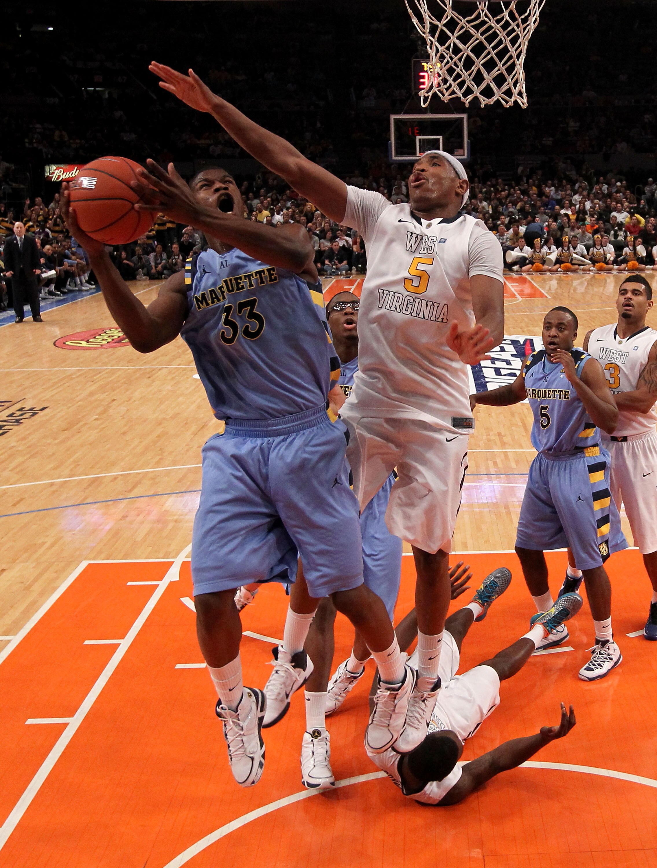 NEW YORK, NY - MARCH 09:  Jimmy Butler #33 of the Marquette Golden Eagles shoots over Kevin Jones #5 of the West Virginia Mountaineers during the second round of the 2011 Big East Men's Basketball Tournament presented by American Eagle Outfitters at Madis