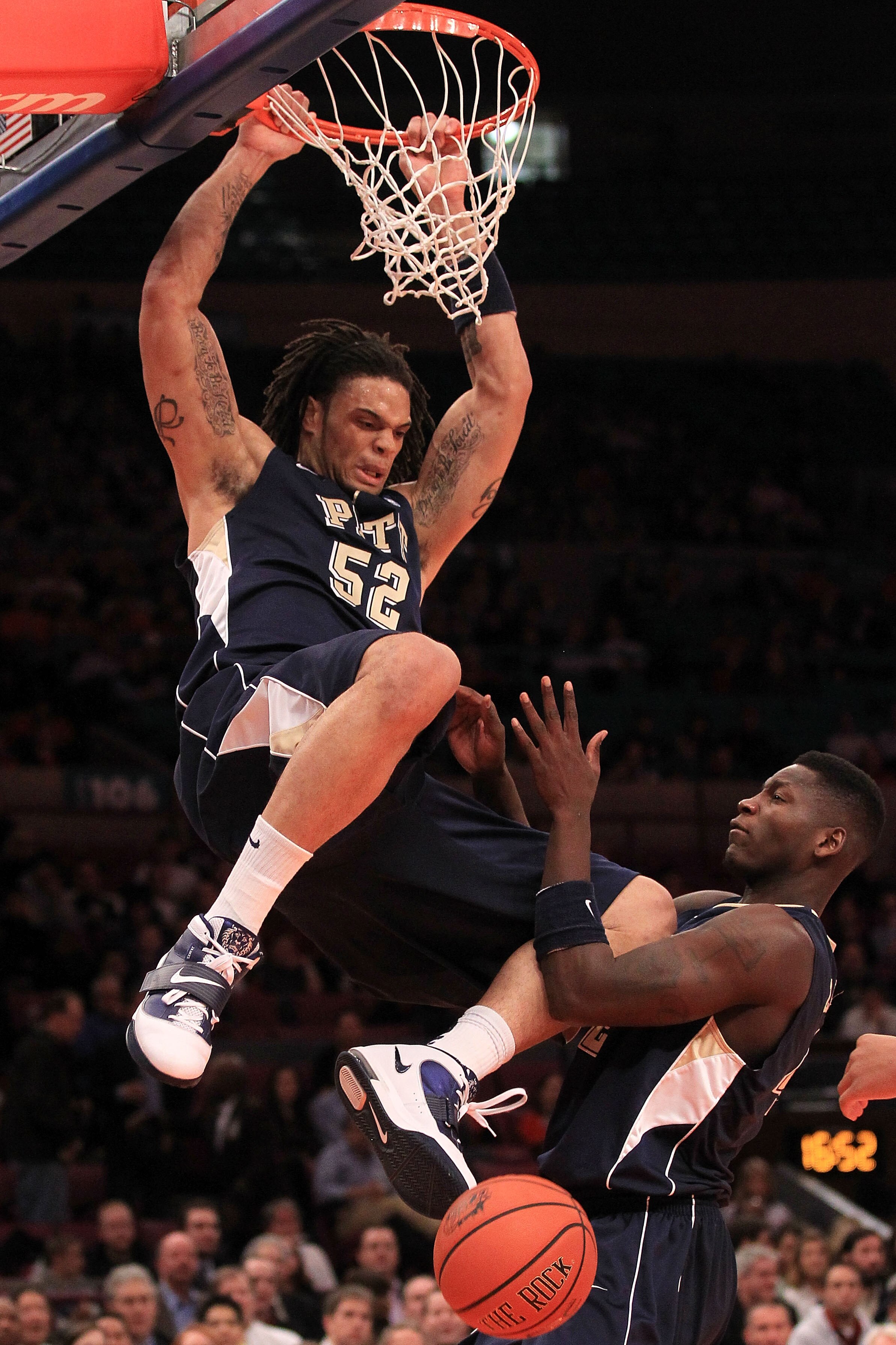 NEW YORK - NOVEMBER 19: Gary McGhee #52 of the Pittsburgh Panthers hangs on the ring after a slam dunk against the Texas Longhorns during the Championship game of the 2k Sports Classic at Madison Square Garden on November 19, 2010 in New York, New York.