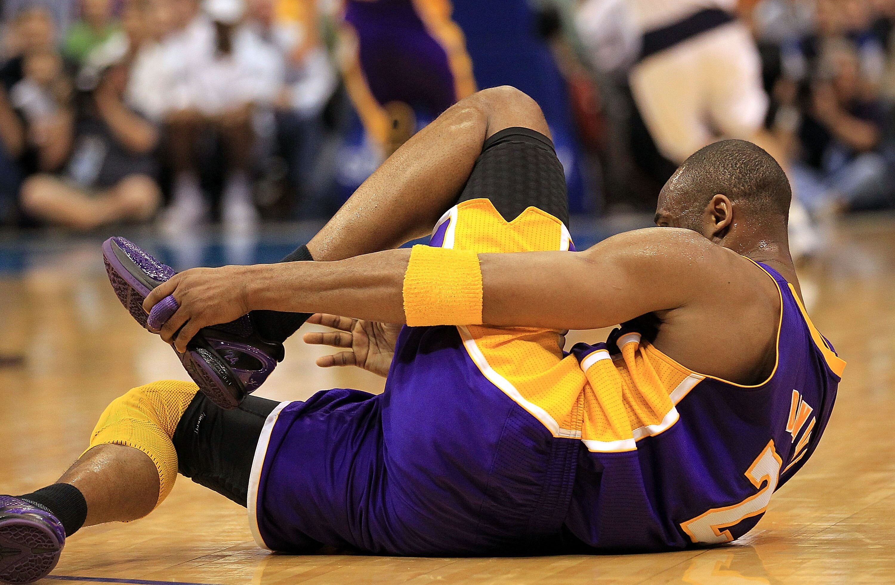 DALLAS, TX - MARCH 12:  Guard Kobe Bryant #24 of the Los Angeles Lakers grabs his foot after suffering an injury during play against the Dallas Mavericks at American Airlines Center on March 12, 2011 in Dallas, Texas.  NOTE TO USER: User expressly acknowl