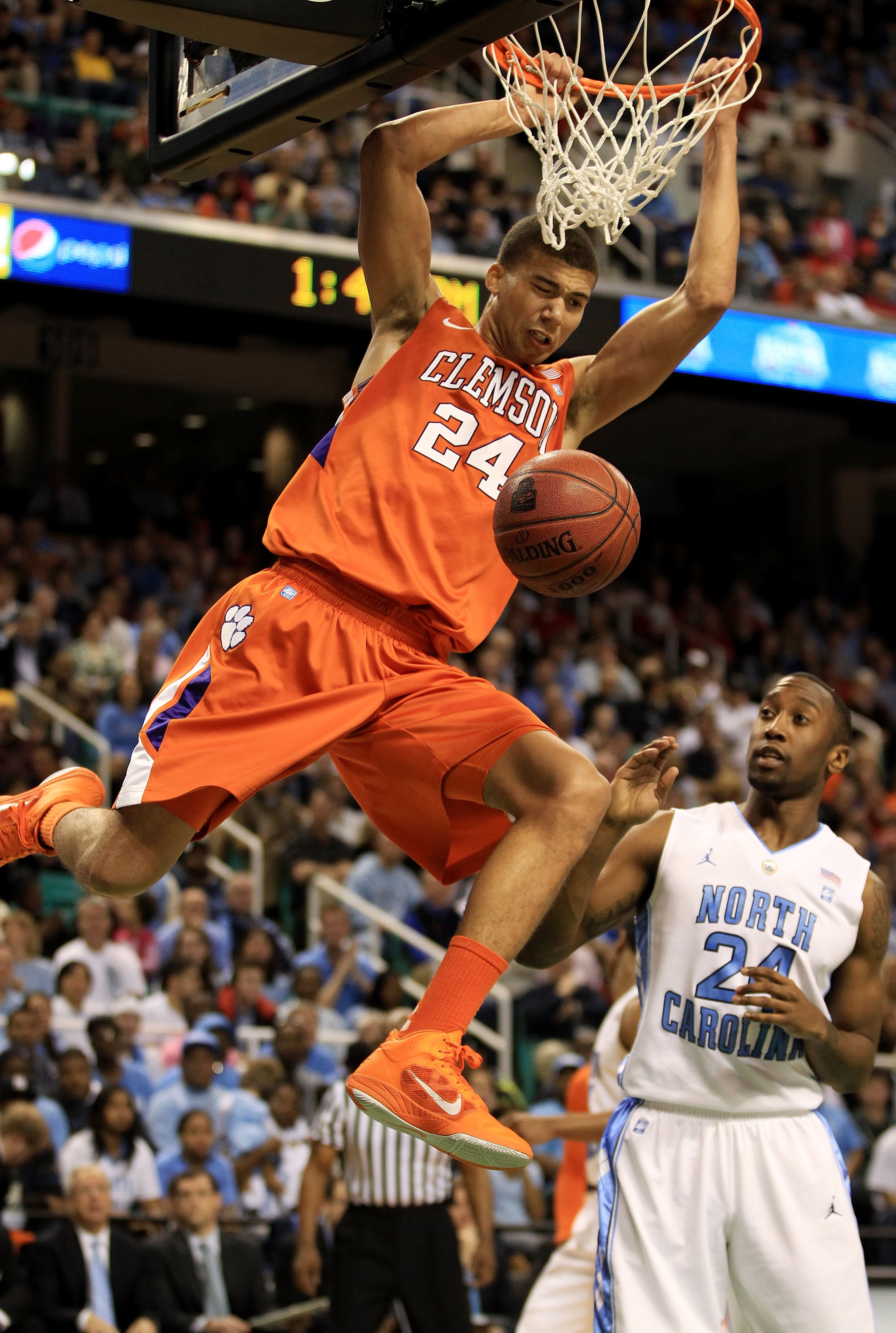 GREENSBORO, NC - MARCH 12:  Milton Jennings #24 of the Clemson Tigers shoots against Justin Watts #24 of the North Carolina Tar Heels during the first half in the semifinals of the 2011 ACC men's basketball tournament at the Greensboro Coliseum on March 1