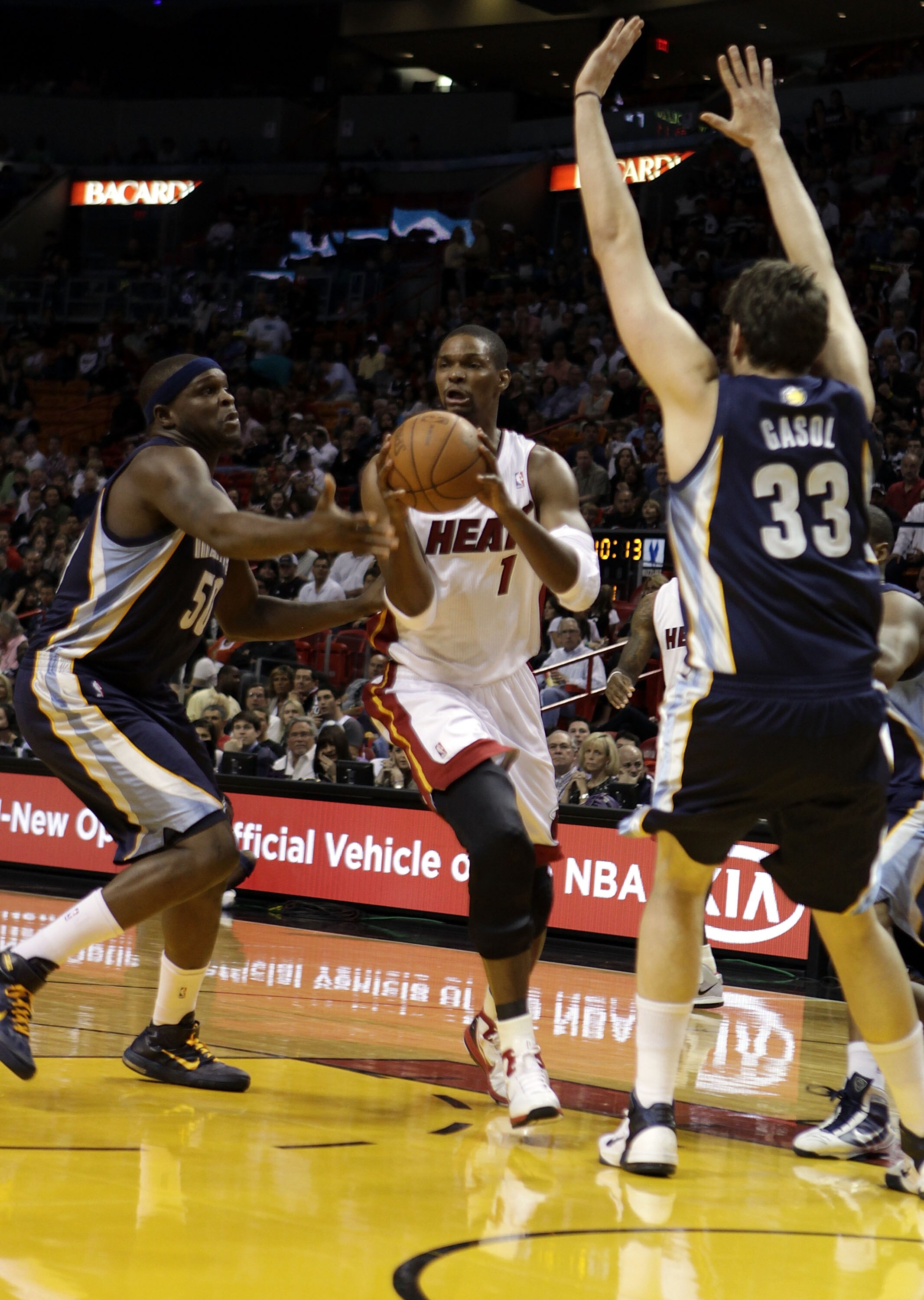 MIAMI - MARCH 12:  Forward Chris Bosh #1 of the Miami Heat drives against Zach Randolph #50 (L) and Marc Gasol #33 of the Memphis Grizzlies at American Airlines Arena on March 12, 2011 in Miami, Florida. NOTE TO USER: User expressly acknowledges and agree