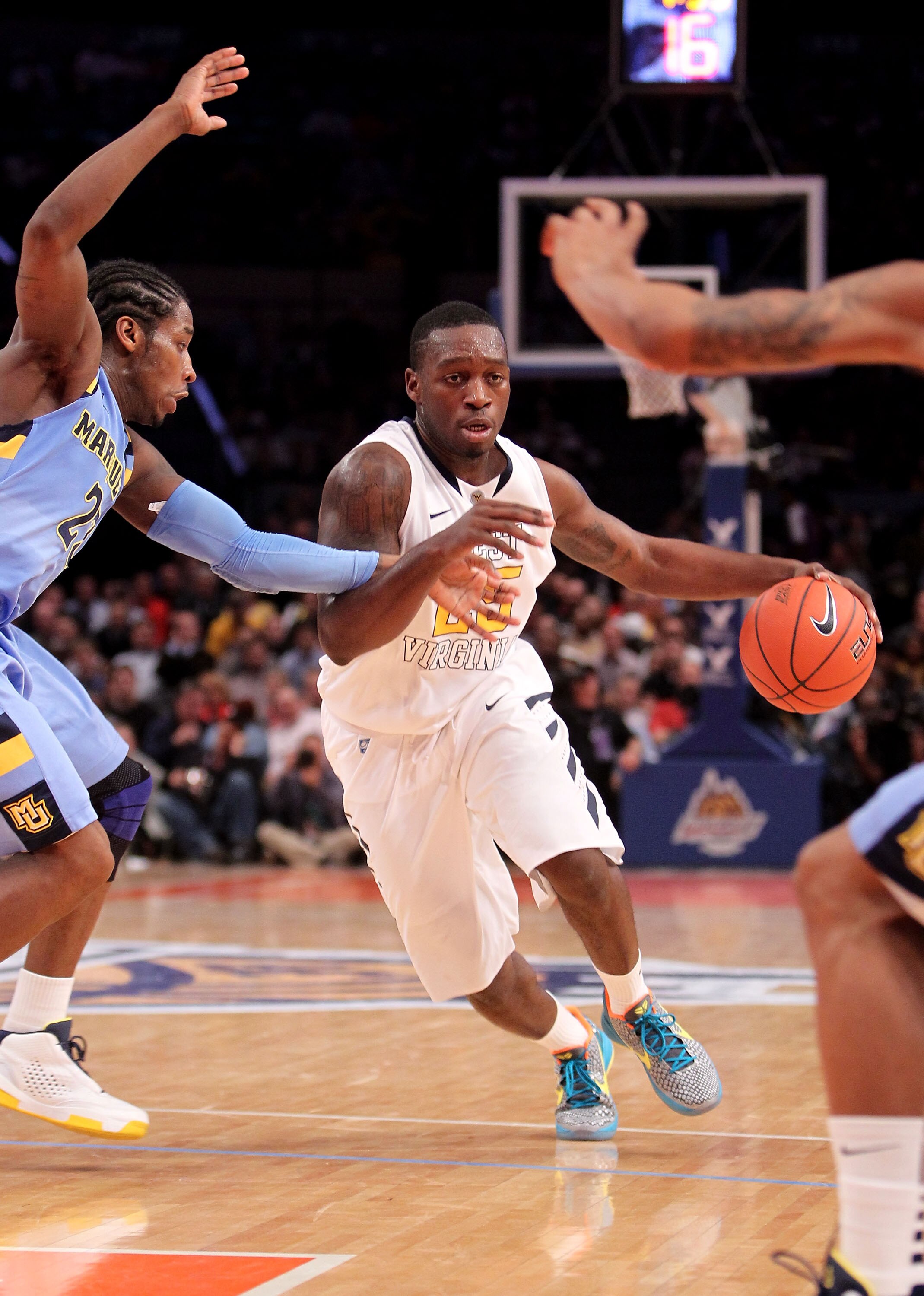 NEW YORK, NY - MARCH 09: Darryl Bryant #25 of the West Virginia Mountaineers dribbles passed Dwight Buycks #23 of the Marquette Golden Eagles during the second round of the 2011 Big East Men's Basketball Tournament presented by American Eagle Outfitters a