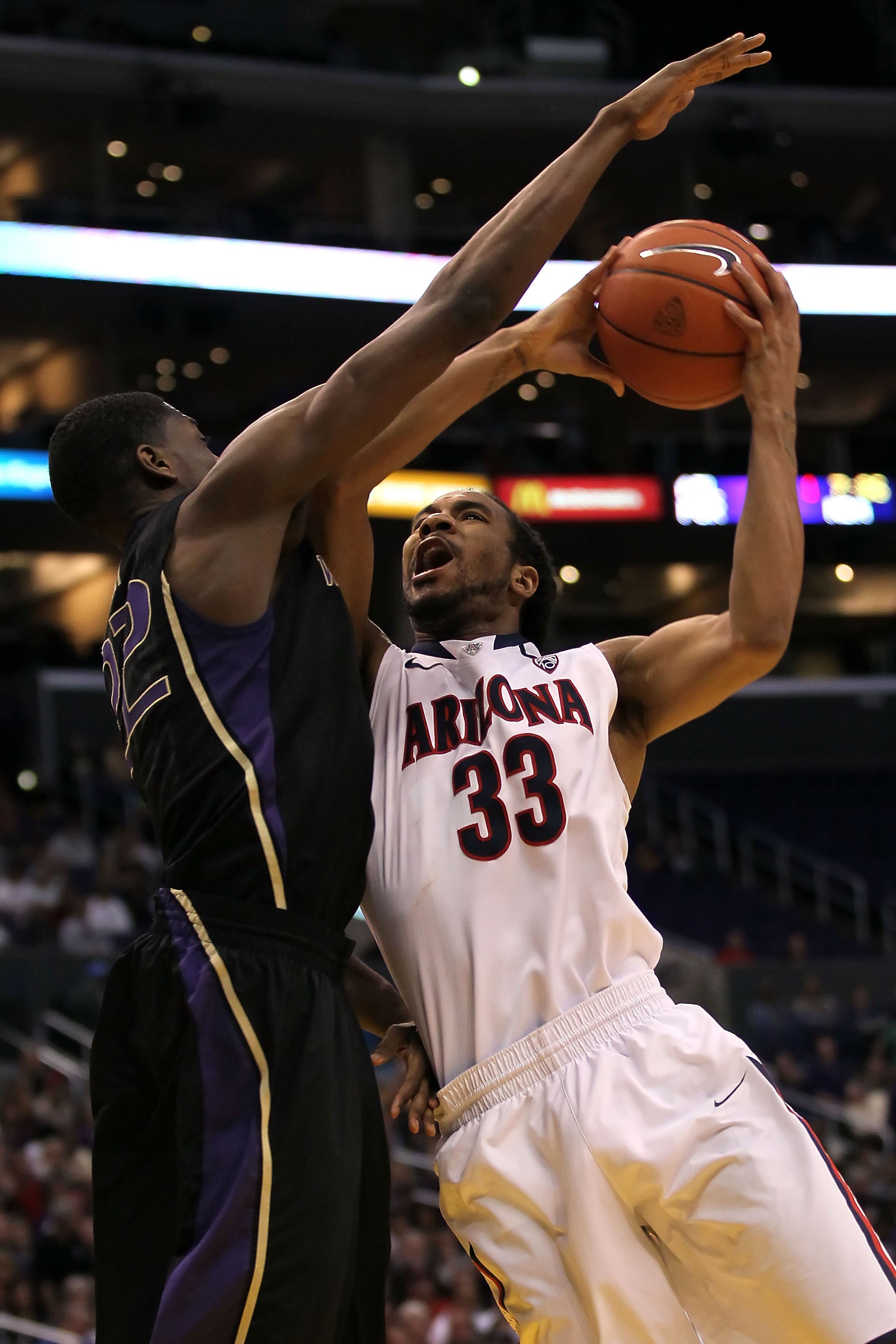 LOS ANGELES, CA - MARCH 12:  Jesse Perry #33 of the Arizona Wildcats shoots over Justin Holiday #22 of the Washington Huskies in the second half in the championship game of the 2011 Pacific Life Pac-10 Men's Basketball Tournament at Staples Center on Marc