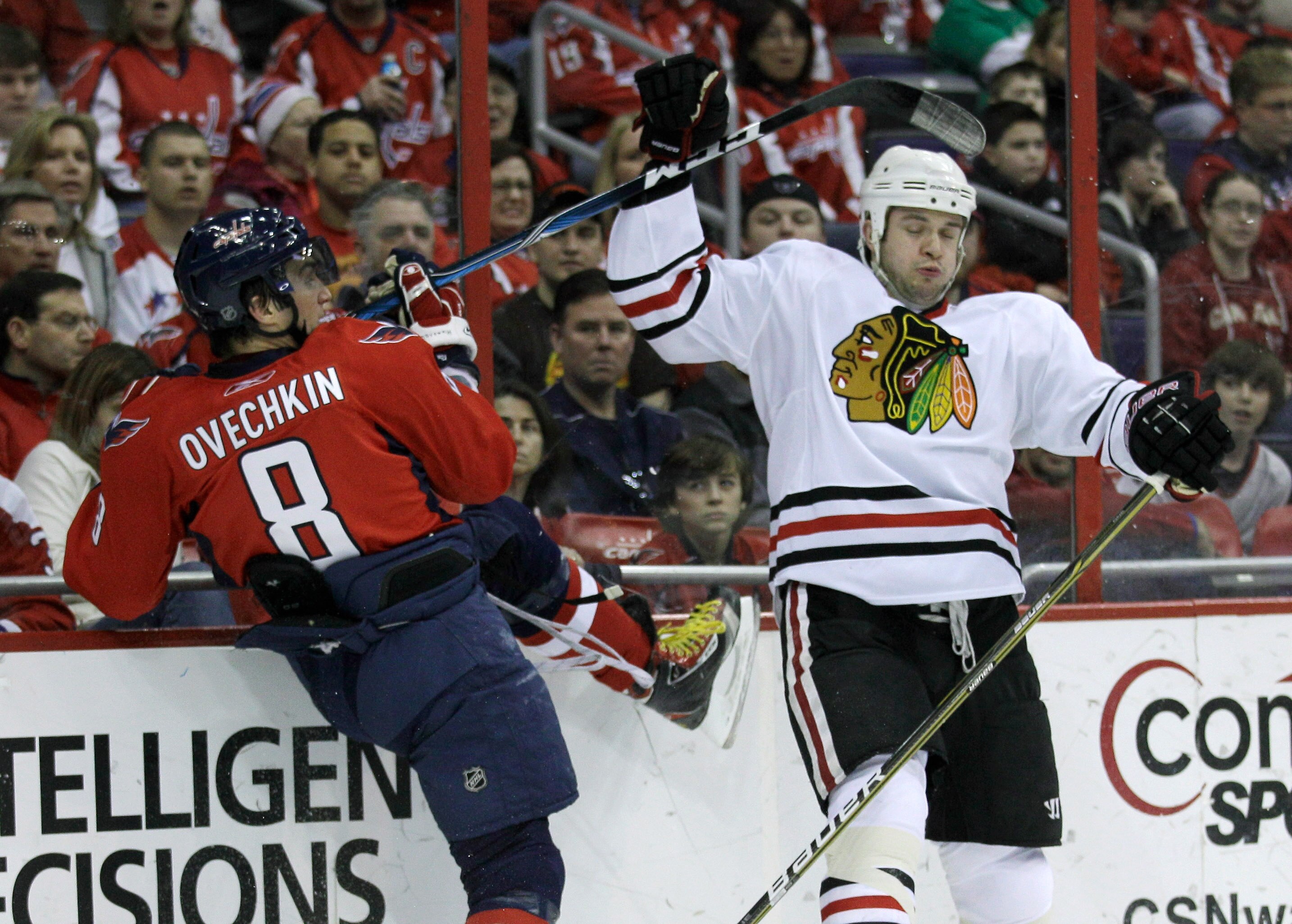 WASHINGTON, DC - MARCH 13: Alex Ovechkin #8 of the Washington Capitals and Brent Seabrook #7 of the Chicago Blackhawks collide into the boards during the first period at the Verizon Center on March 13, 2011 in Washington, DC.  (Photo by Rob Carr/Getty Ima