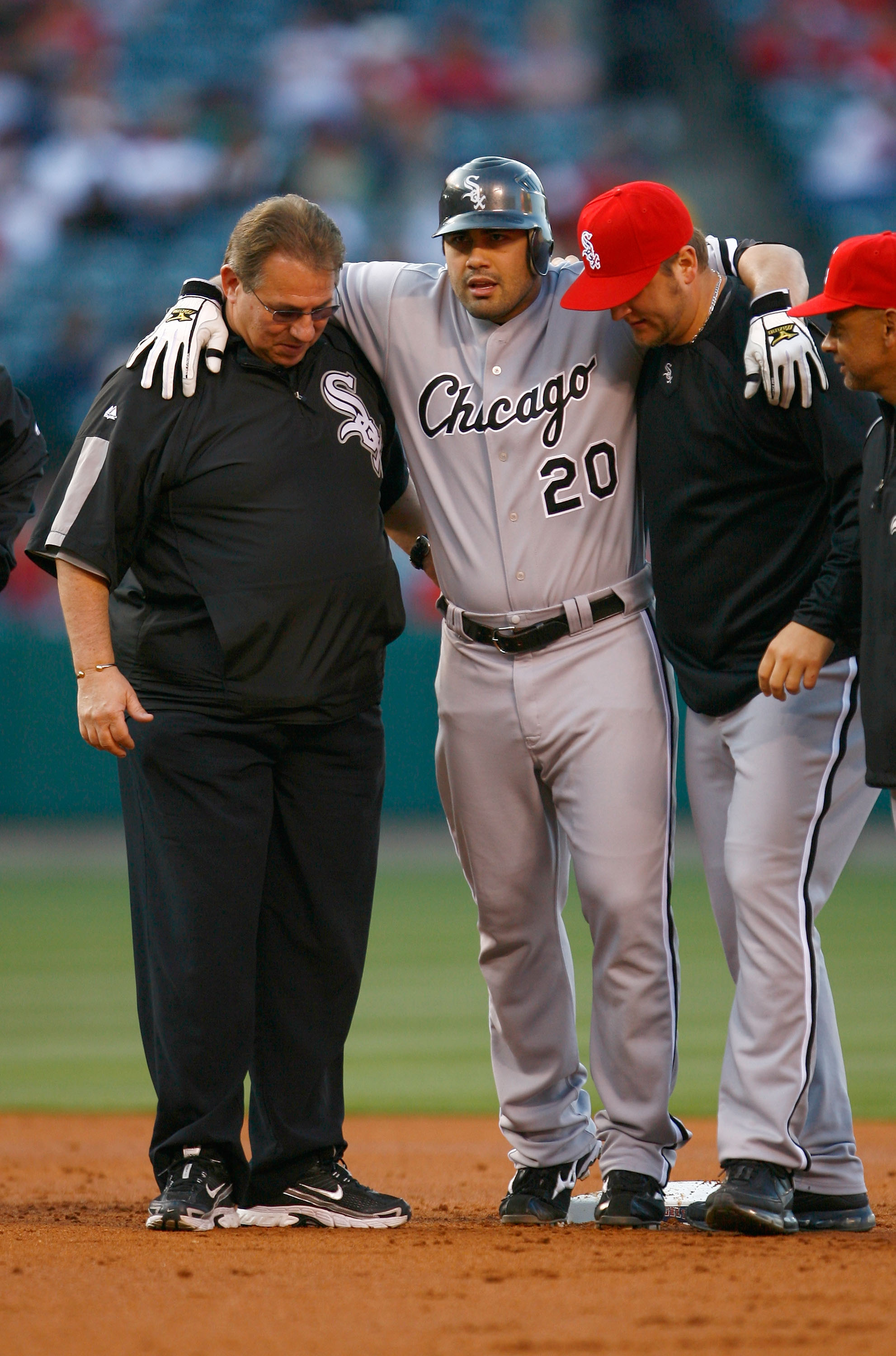 ANAHEIM, CA - MAY 25:  Carlos Quentin #20 of the Chicago White Sox is helped off the field after hitting a double and sustaining an injury in the first inning against the Los Angeles Angels of Anaheim at Angel Stadium on May 25, 2009 in Anaheim, Californi